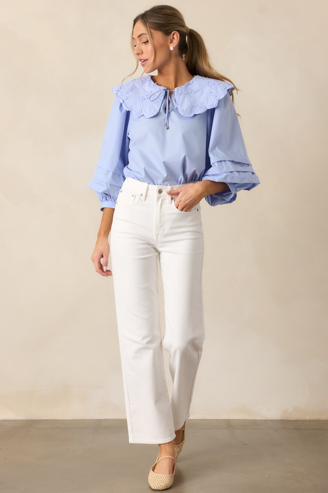 Another full-body view of the sky blue blouse, showcasing the flow of the long puff sleeves, the scalloped collar, and the self-tie keyhole in the front.