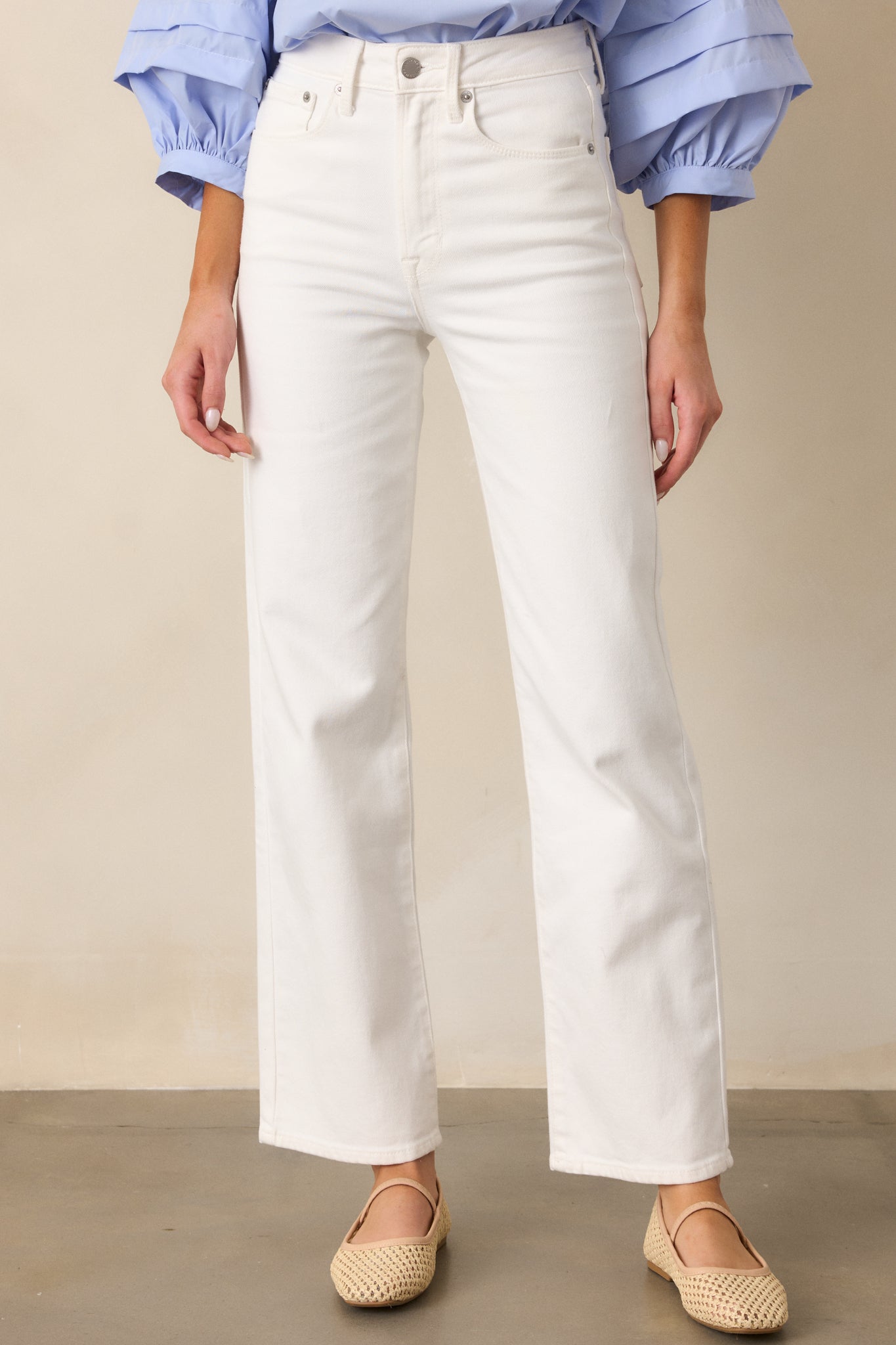 A close-up shot of the white jeans from the front, highlighting the clean, straight leg cut, with a focus on the front pockets and the belt loops.