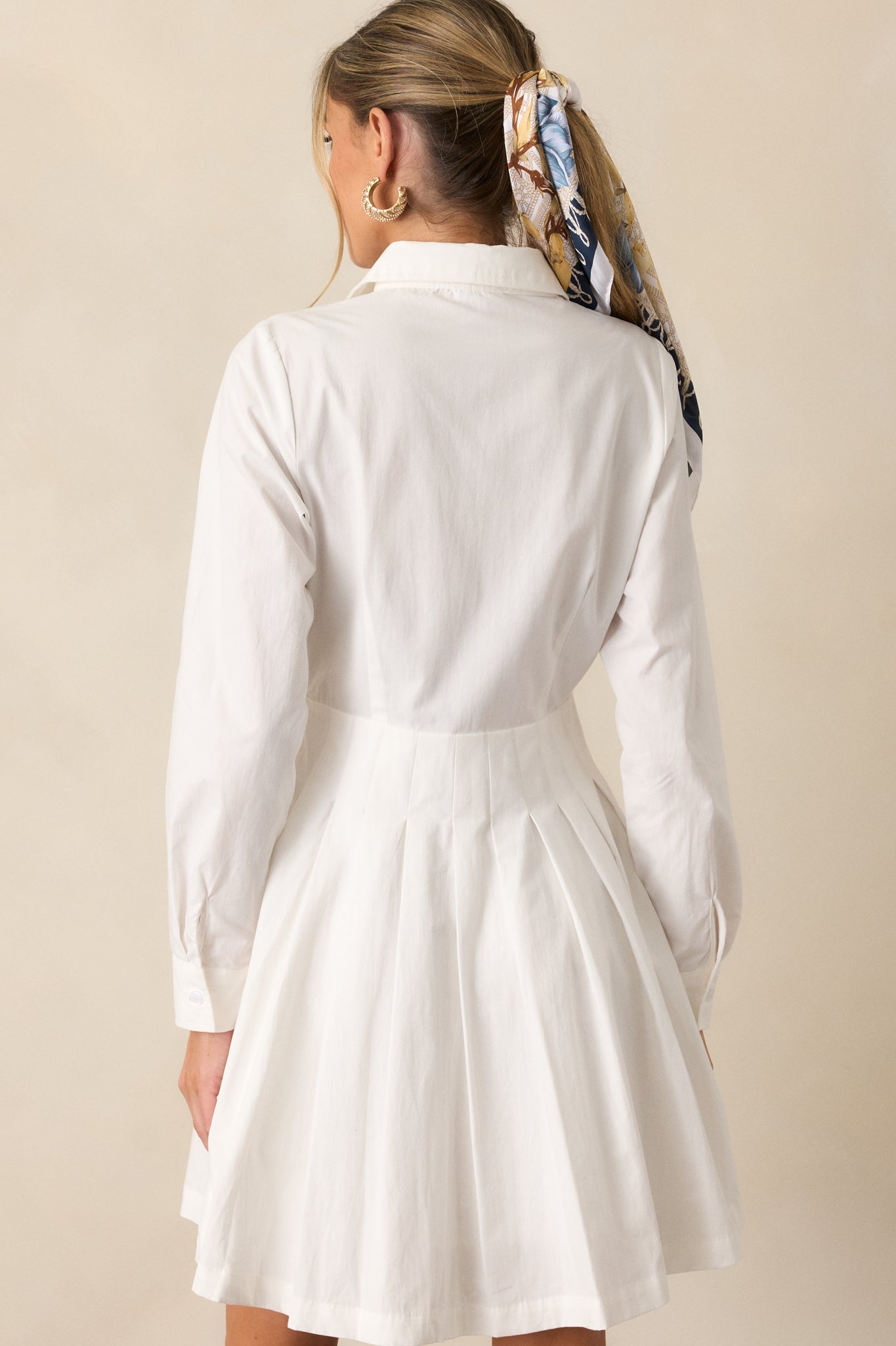 A view of the white mini dress from behind, showcasing its sleek design and mini length.