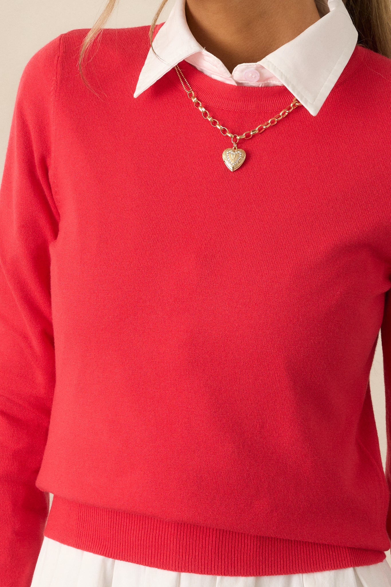 A detailed close-up showing the texture of the rib-knit hems and the soft fabric of the red sweater, highlighting its cozy design.