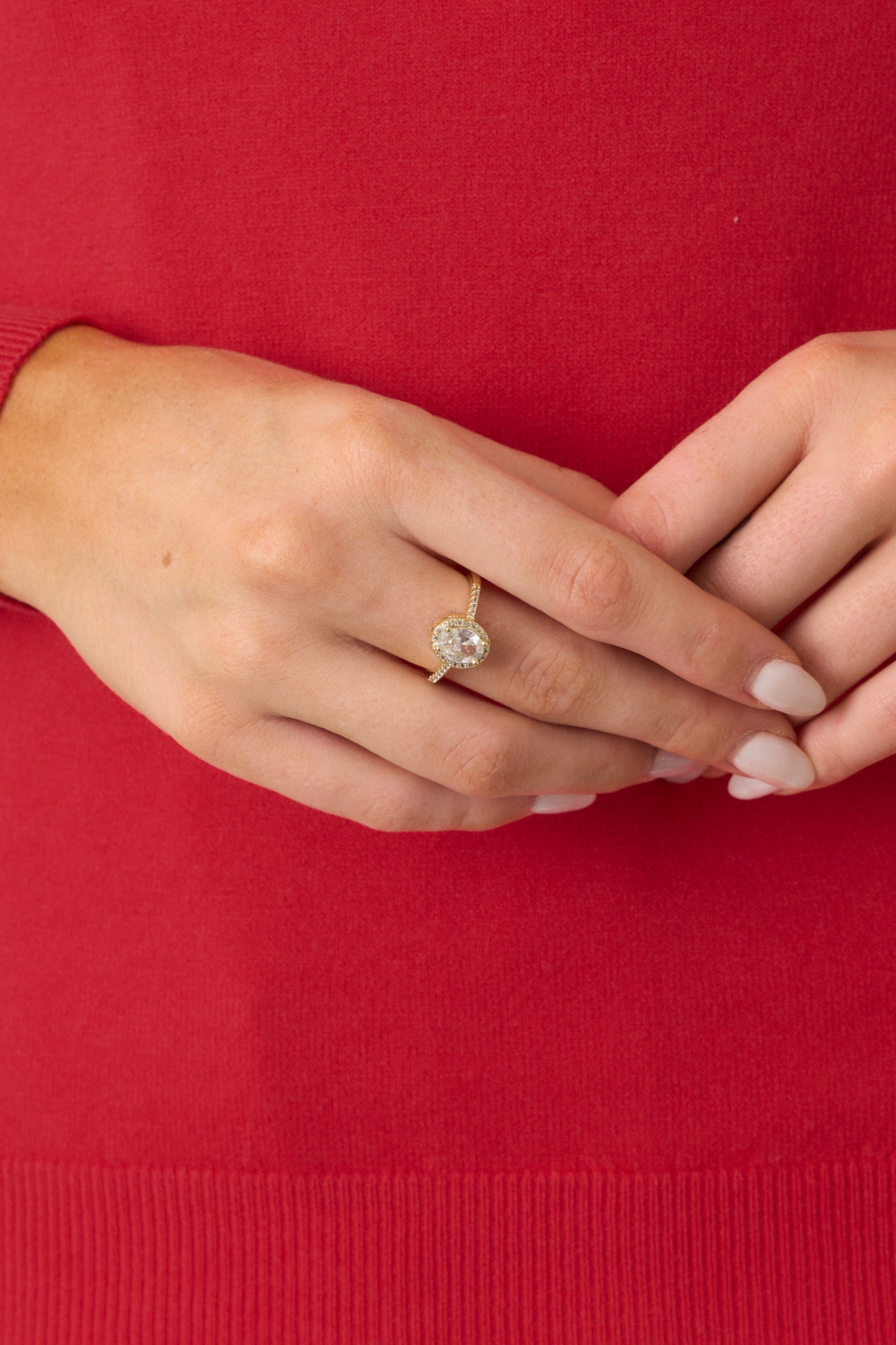 A detailed view of the gold ring, emphasizing the sparkling large rhinestone at the center, with the smaller rhinestones surrounding it and decorating the band, showcasing the ring’s glamorous design.