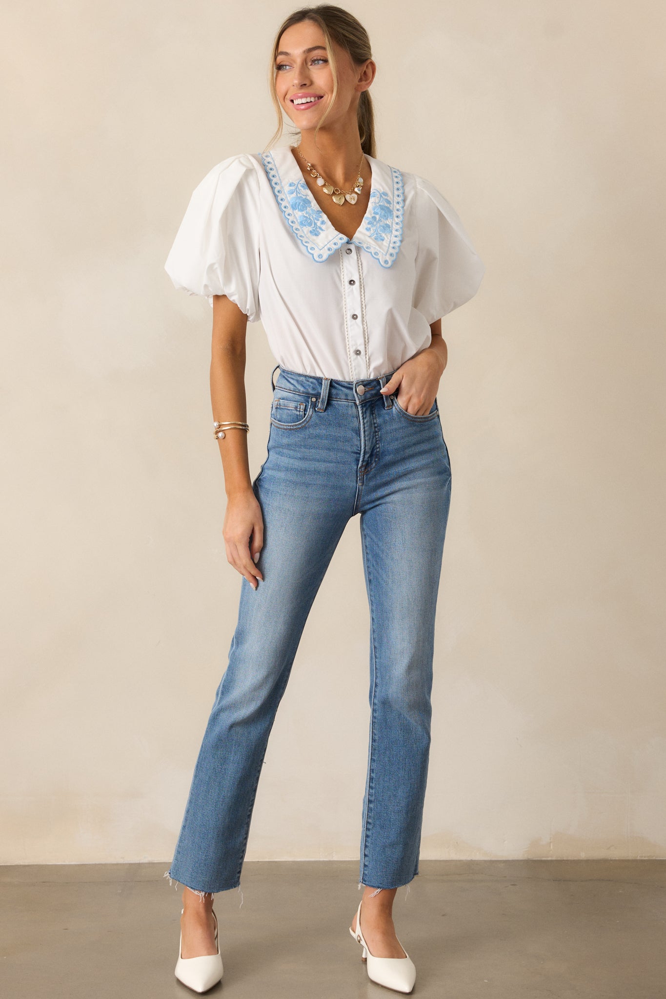 A white top showcasing the short puff sleeves and button front design with a classic, relaxed fit.