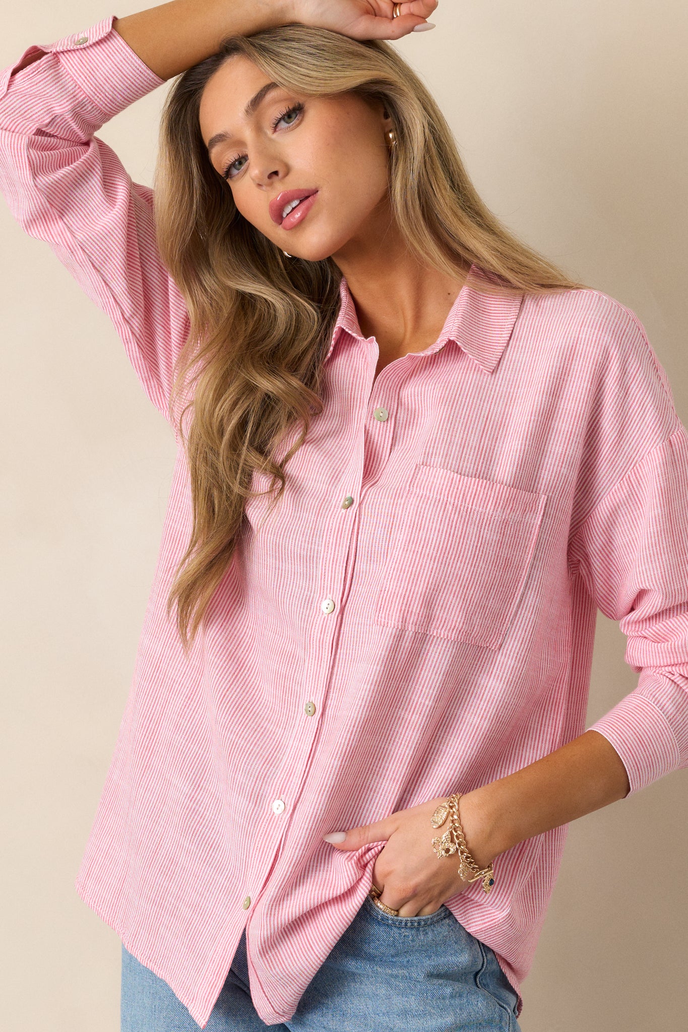 A side view of the porcelain rose blouse, highlighting the relaxed fit and button front design, with the long sleeves and front pocket clearly visible.