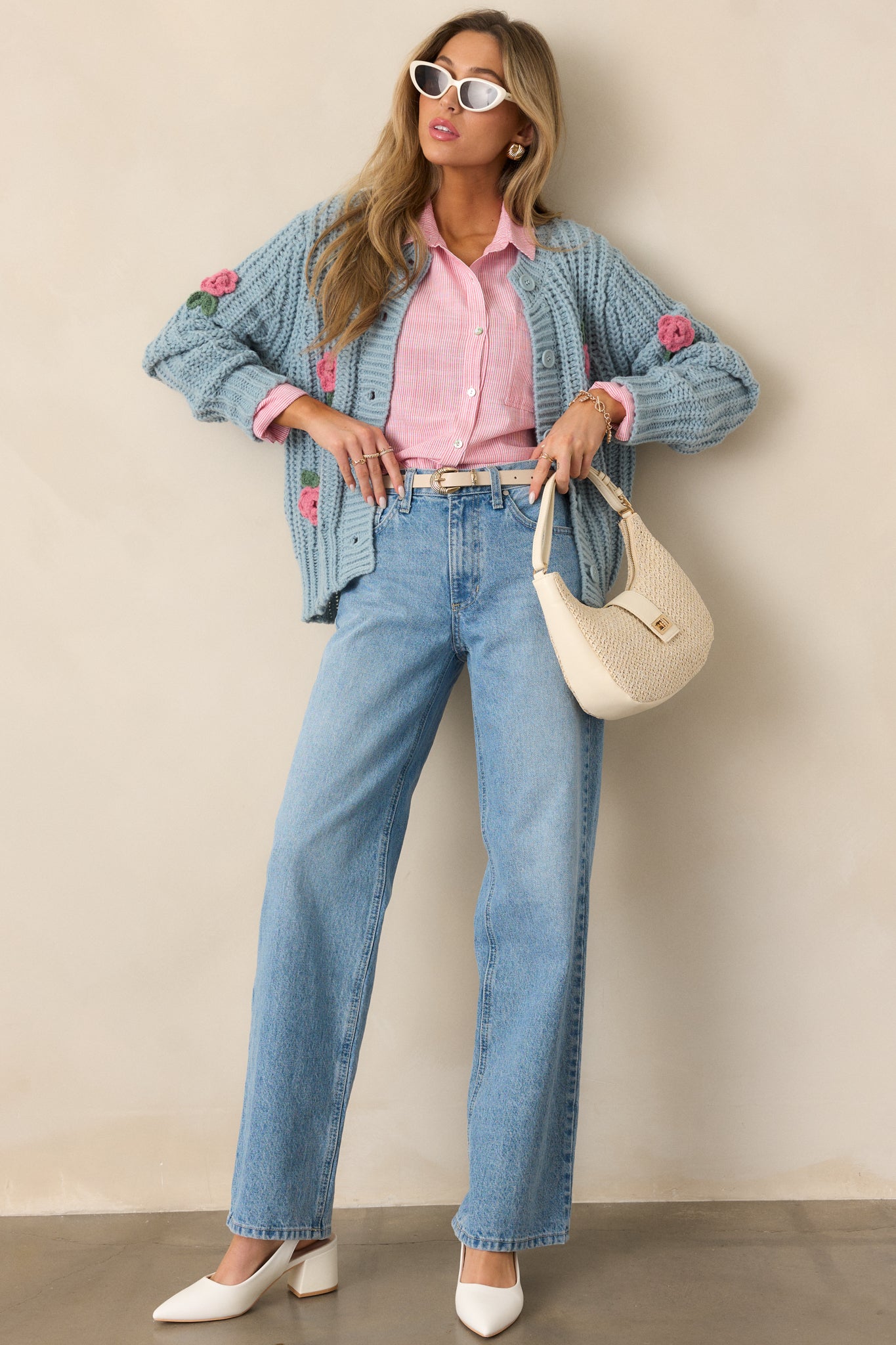 A front view of the teal cardigan, showcasing the relaxed fit, rounded neckline, and button-front design, with the crochet rose detailing visible along the edges.