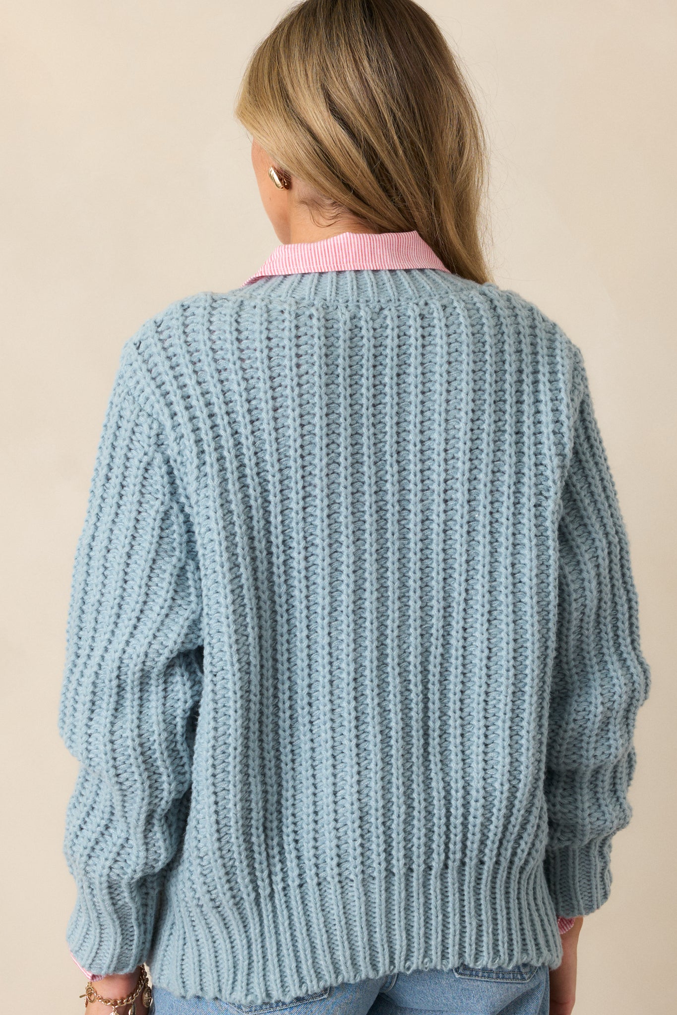 A back view of the teal cardigan, focusing on the smooth knit and relaxed fit, with the buttons subtly visible at the back.