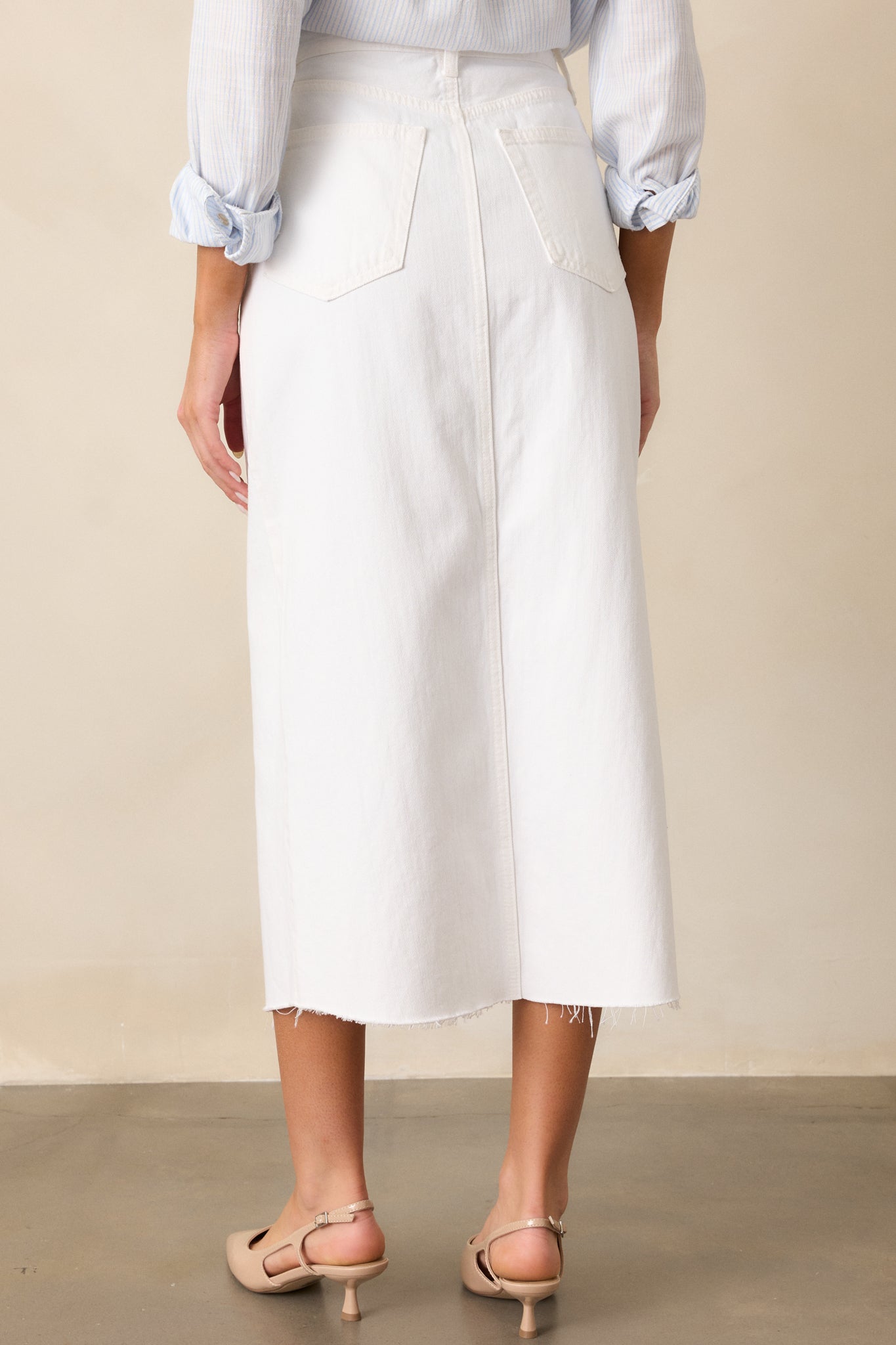 A view of the white skirt from behind, emphasizing the functional back pockets and seamless design.