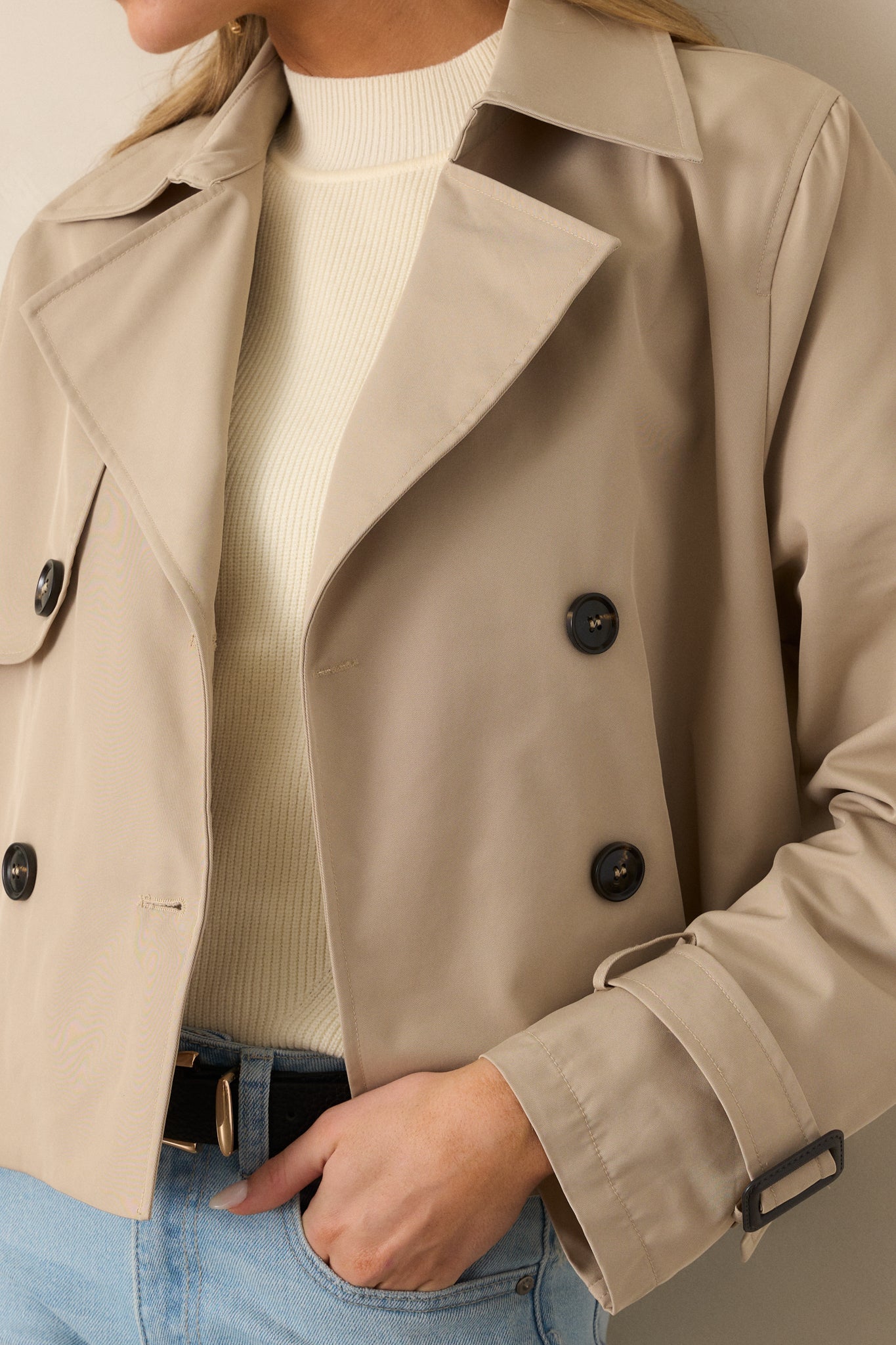 A close-up view of the khaki coat's functional button front and double-lapel neckline, emphasizing fine craftsmanship.