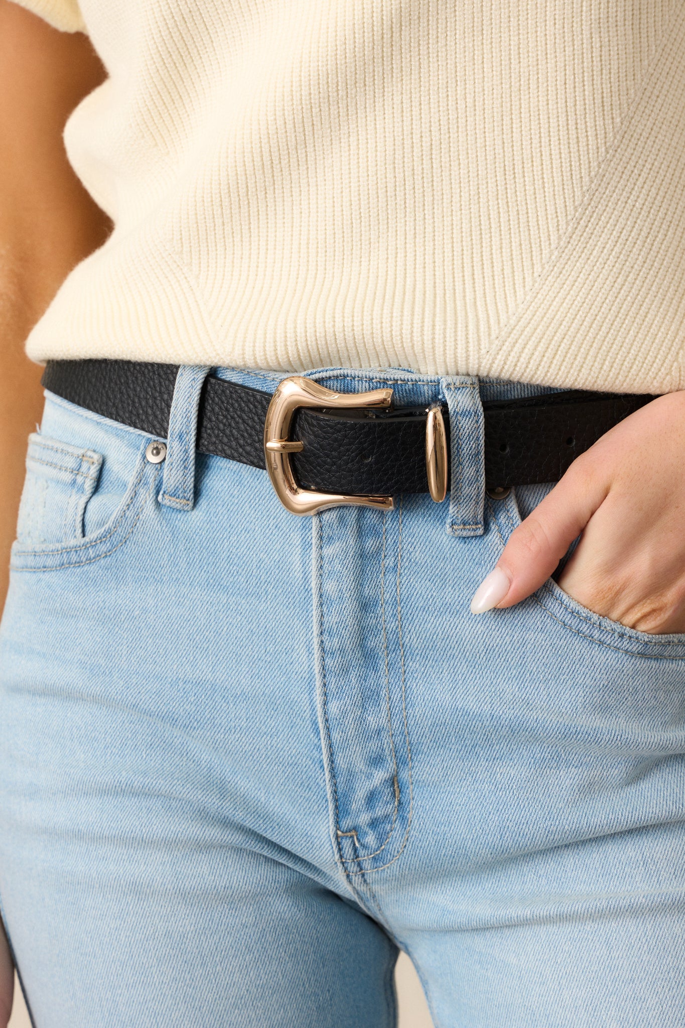 A black belt with a textured faux leather material, accented by a gold horseshoe pin buckle that stands out with a sleek finish.