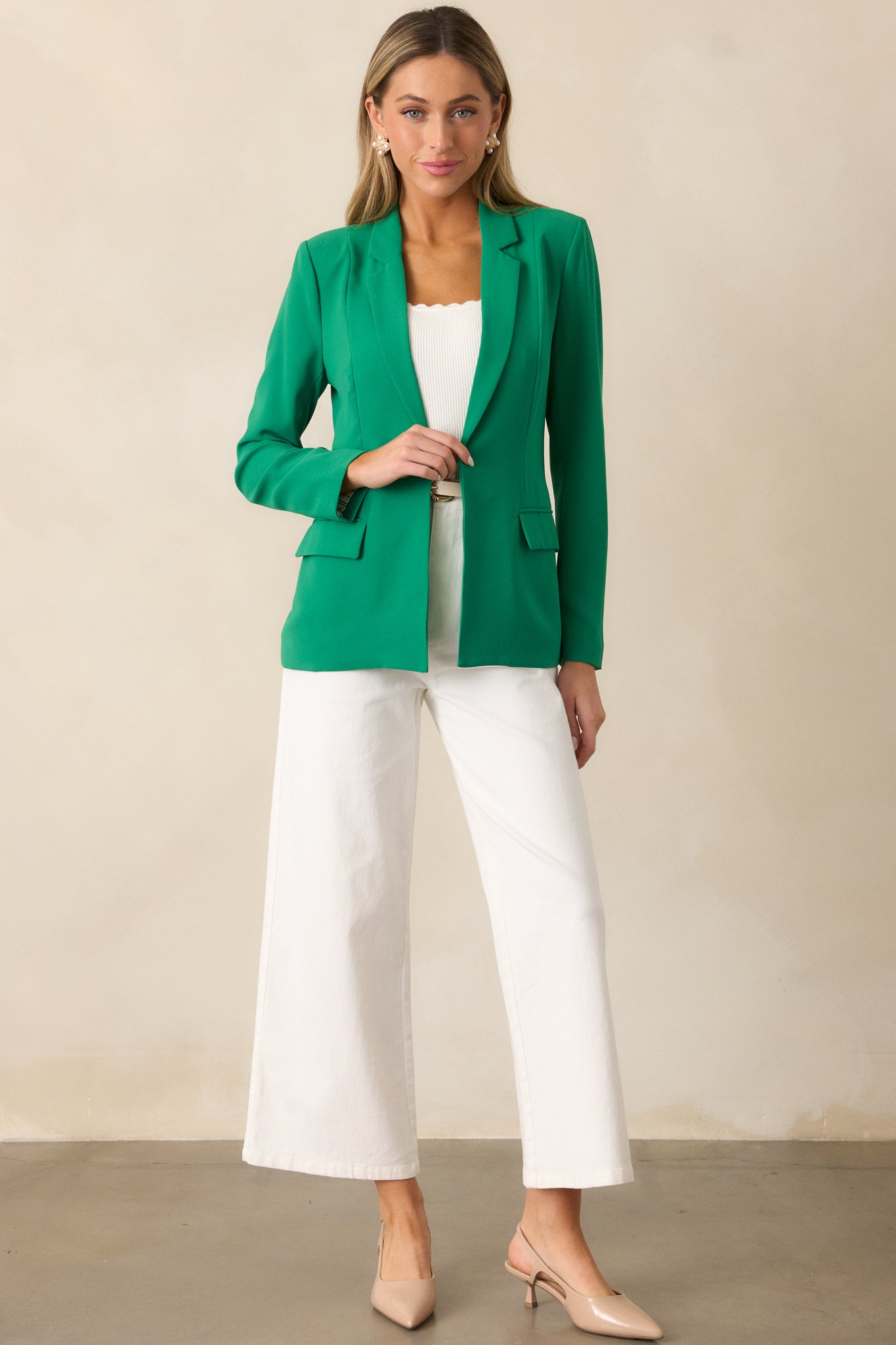 Green blazer featuring a notched lapel collared neckline, long sleeves, and functional pockets, styled with no button closure.