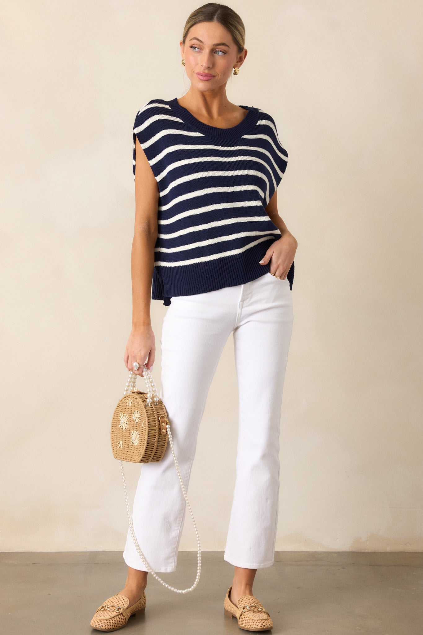 Navy sweater top with horizontal stripes, a ribbed crew neckline, short sleeves, and a split ribbed hemline.