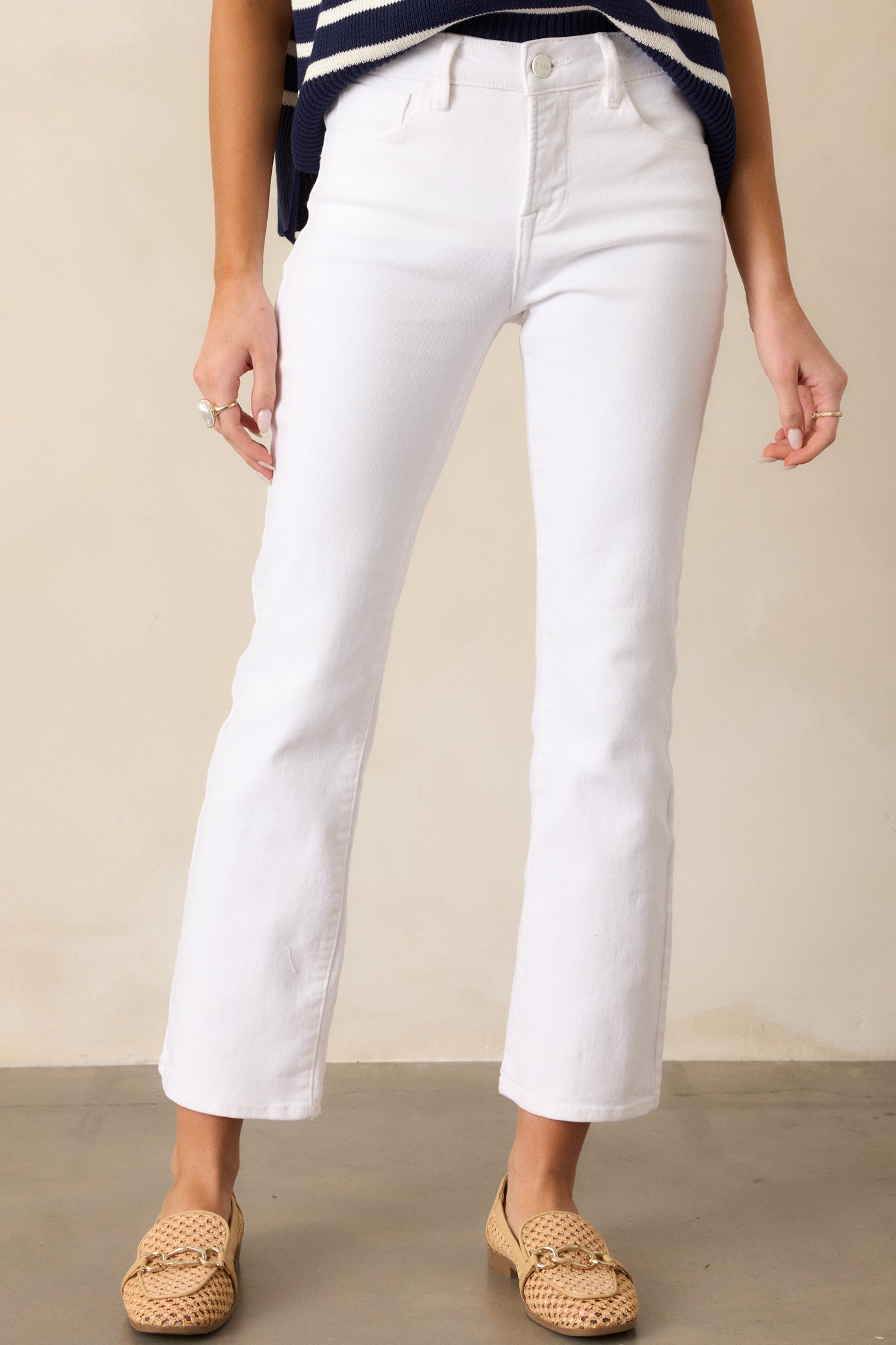 Close-up of the white jeans’ high-waist design, functional belt loops, and button-zipper closure, highlighting the clean, tailored fit.