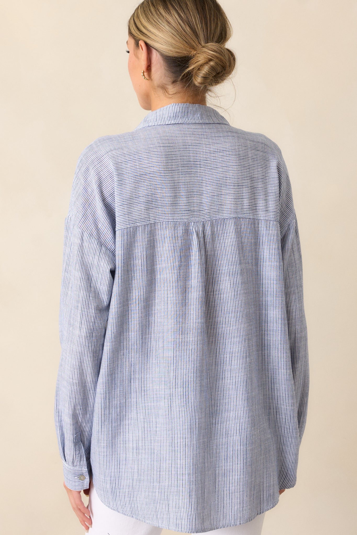 A back view of the stripe denim blouse, emphasizing the alignment of the stripe pattern, collared neckline, and the relaxed fit of the blouse.