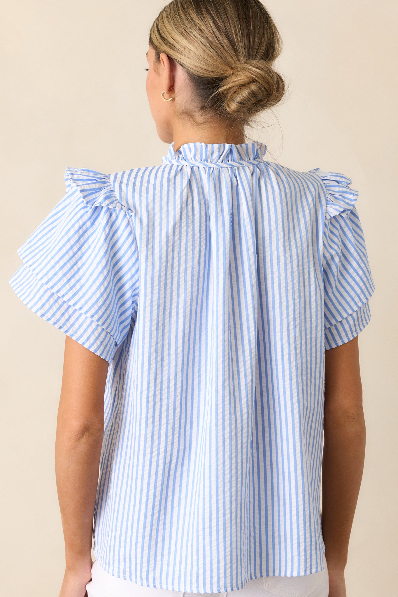 Back view of the Blue Stripe Blouse displaying the vertical blue and white stripe pattern and neatly finished design.