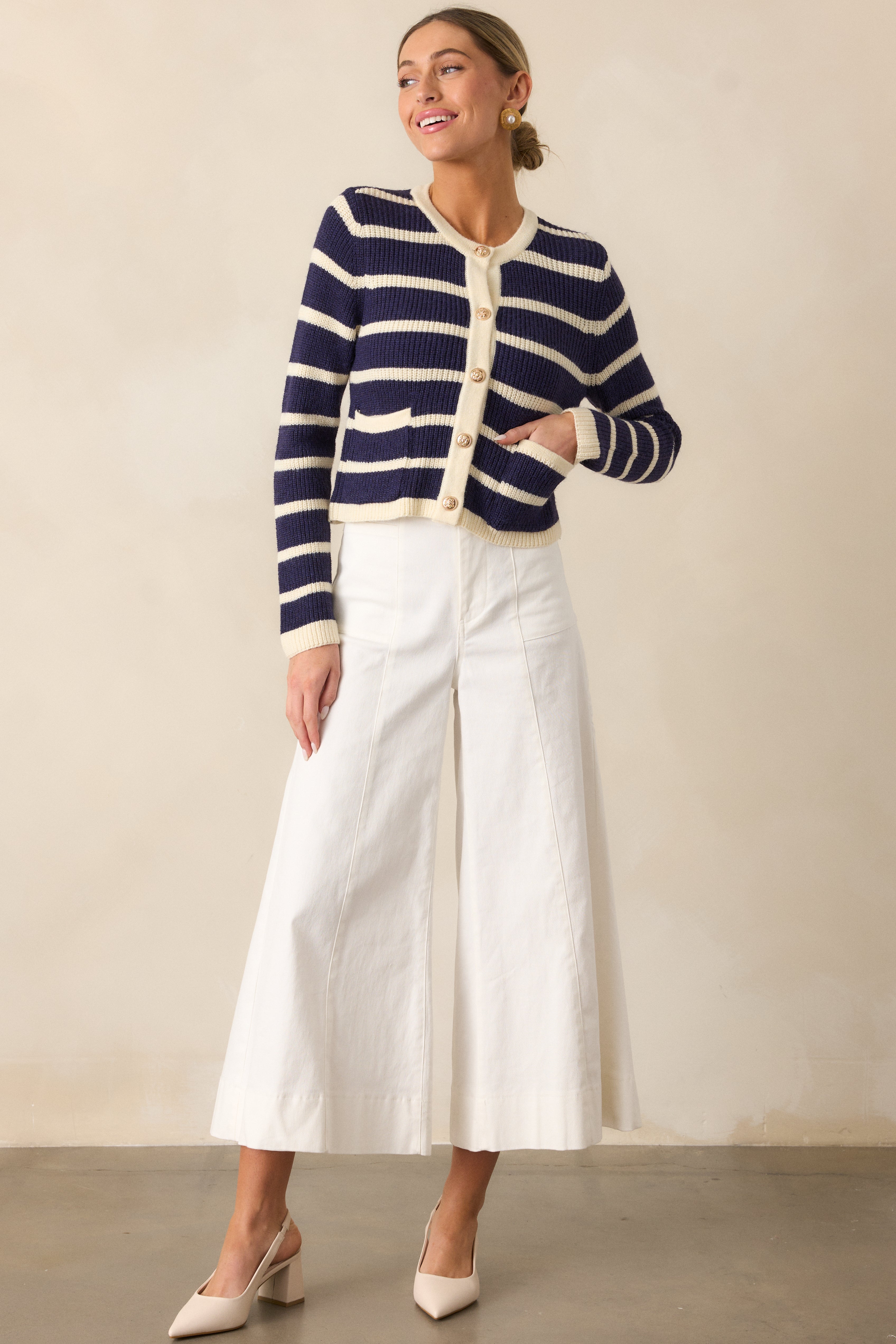 A full-length view of the navy stripe cardigan, highlighting its round neckline and tailored cropped design.