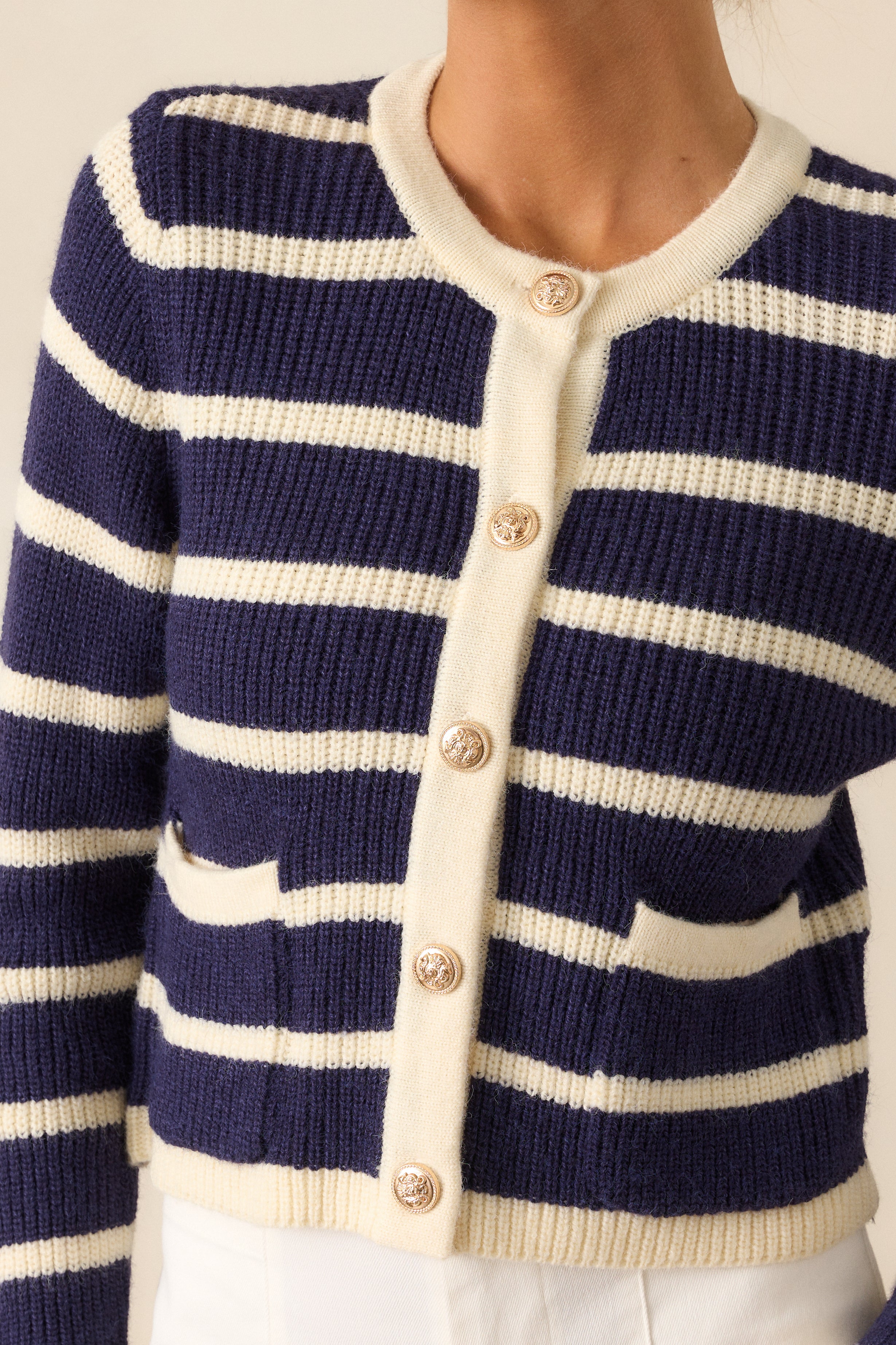 A close-up view of the navy stripe cardigan's metallic buttons, emphasizing their polished and functional design.