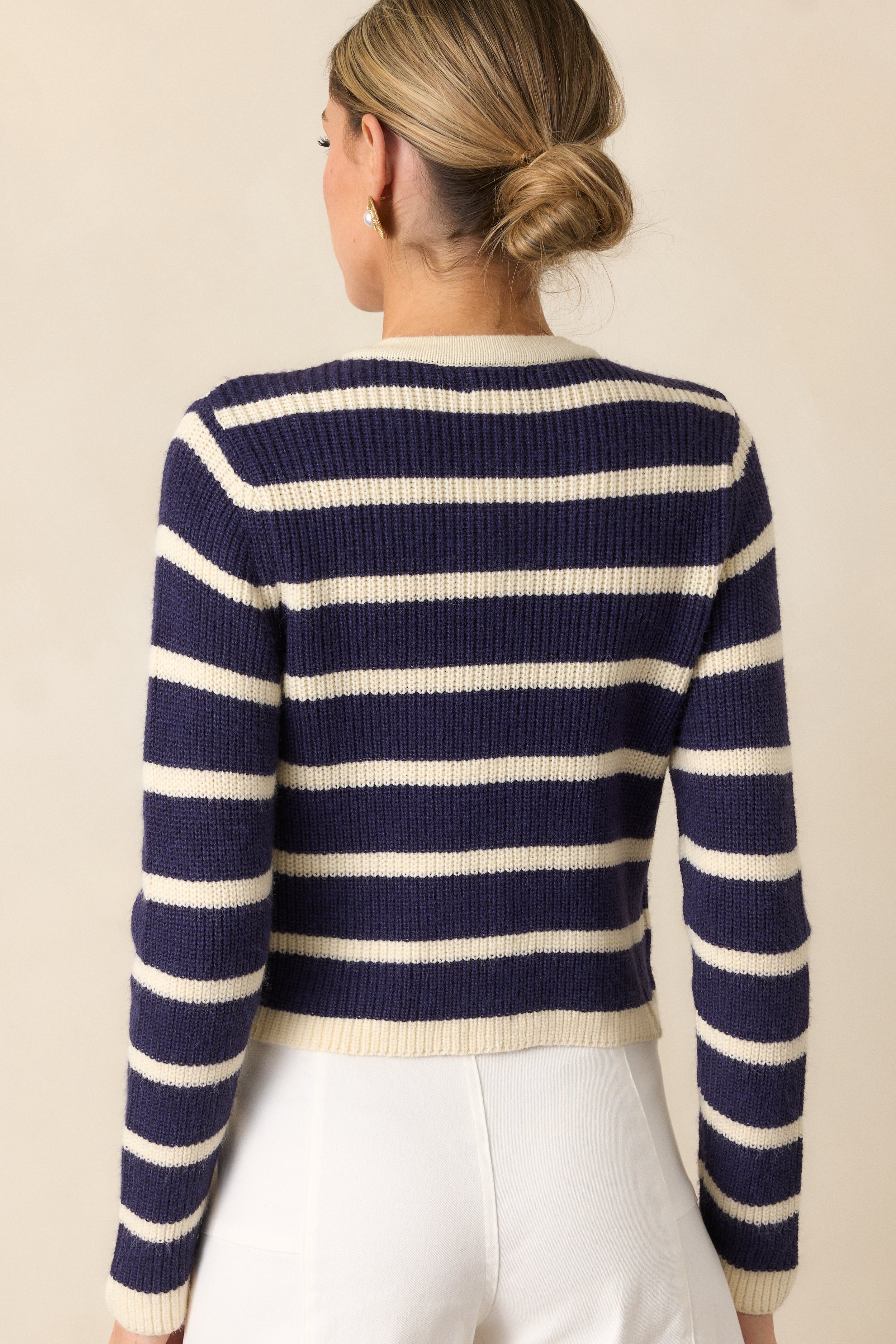 A back view of the navy stripe cardigan, showcasing its cropped length and evenly spaced stripe pattern.