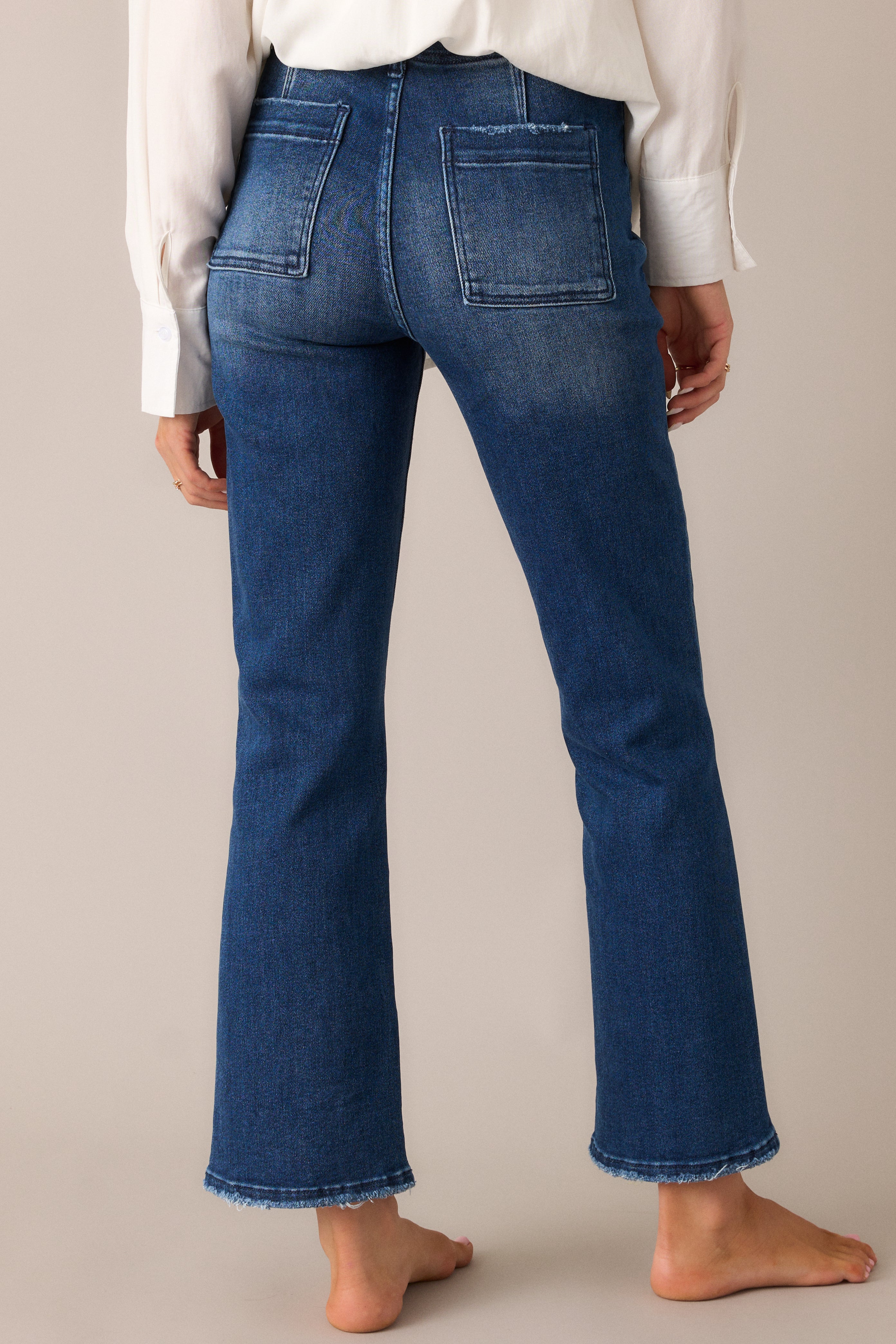 The dark wash jeans from the back, showcasing the high-waisted design, functional back pockets, perfect for a sleek, flattering fit.