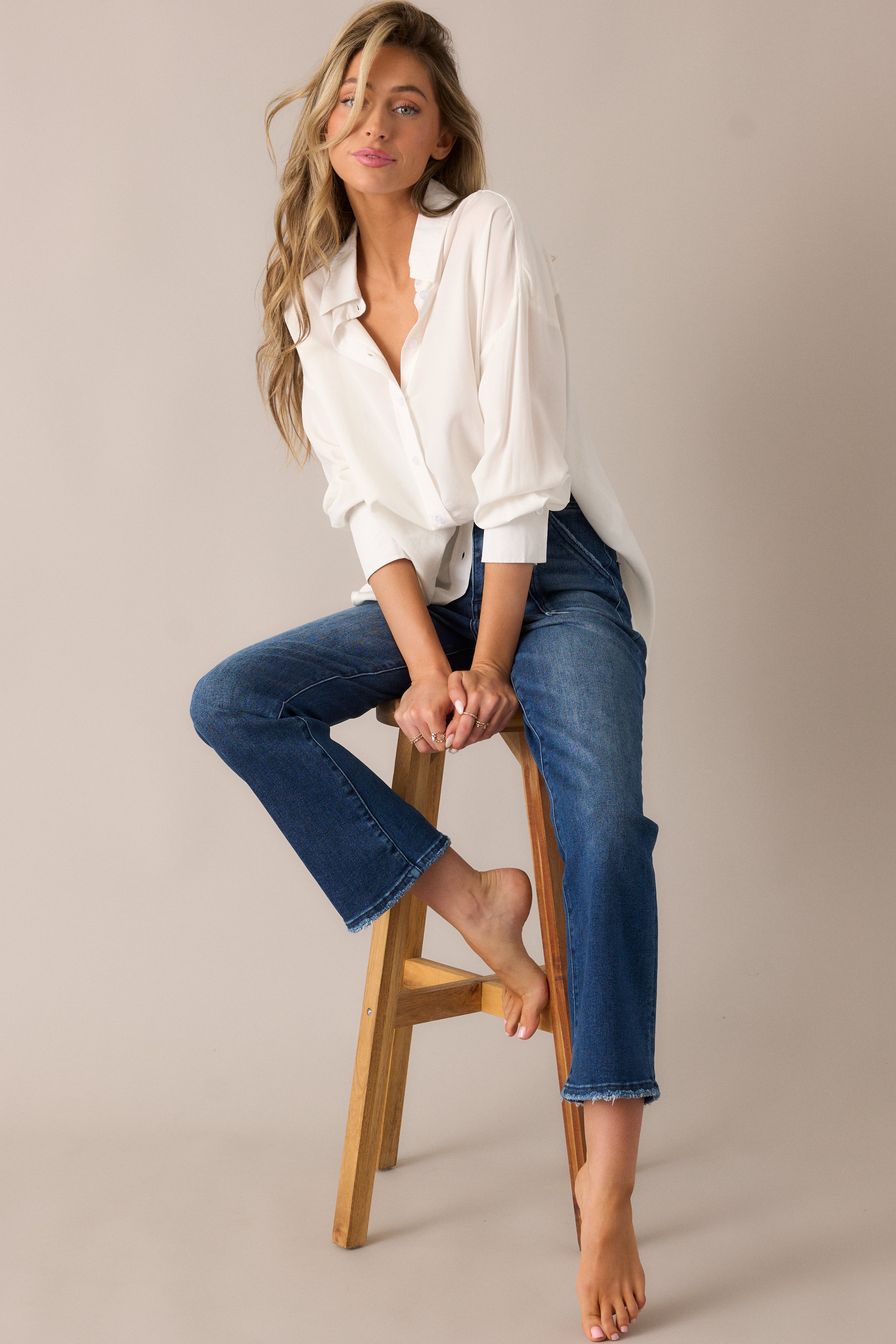 Chic dark wash jeans featuring a flattering high waist, roomy front pockets, and functional back pockets, paired with a button and zipper closure for a streamlined, versatile style.