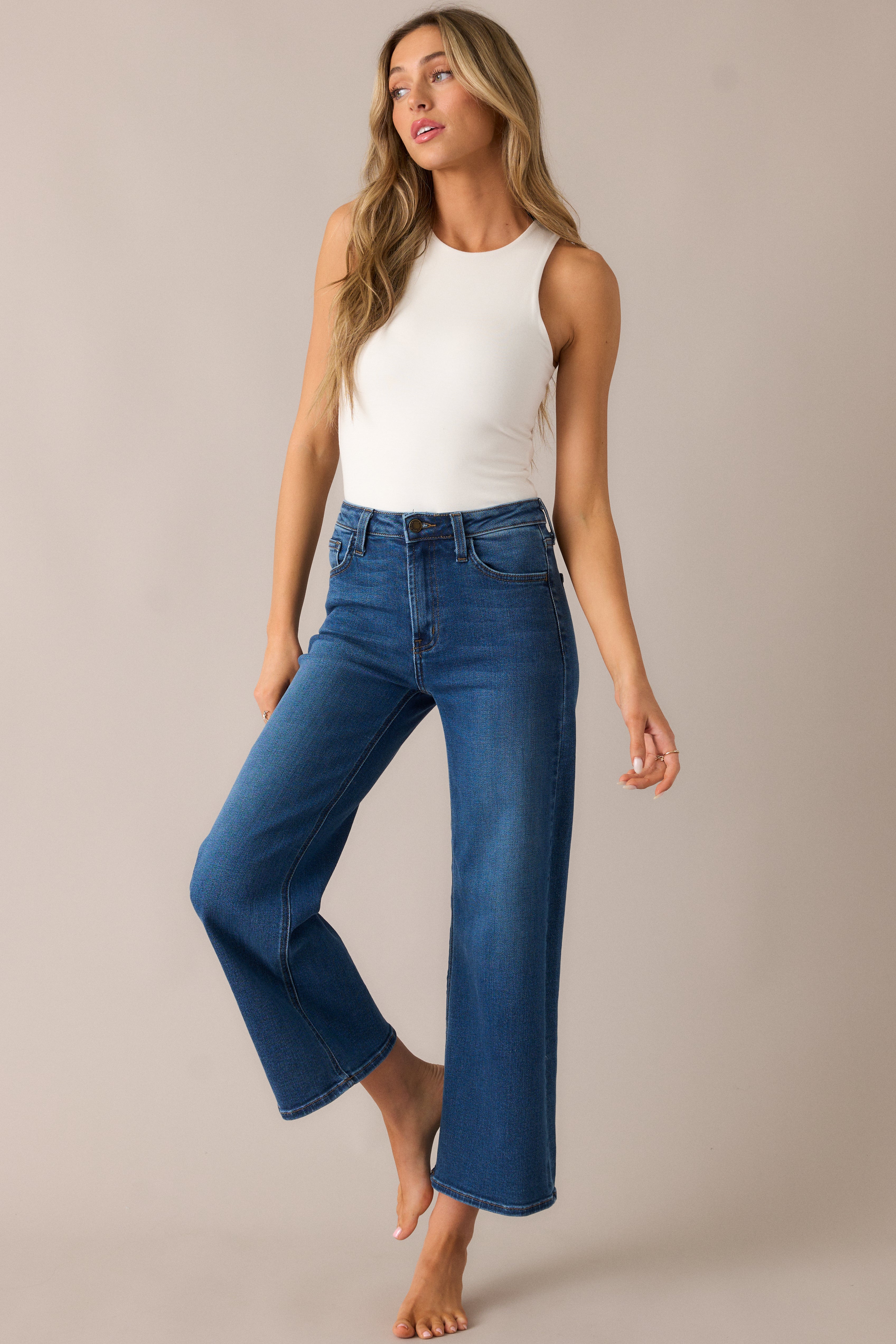 Chic high-waisted wide-leg jeans with a cropped cut, paired with functional front and back pockets, offering a comfortable and trendy silhouette.