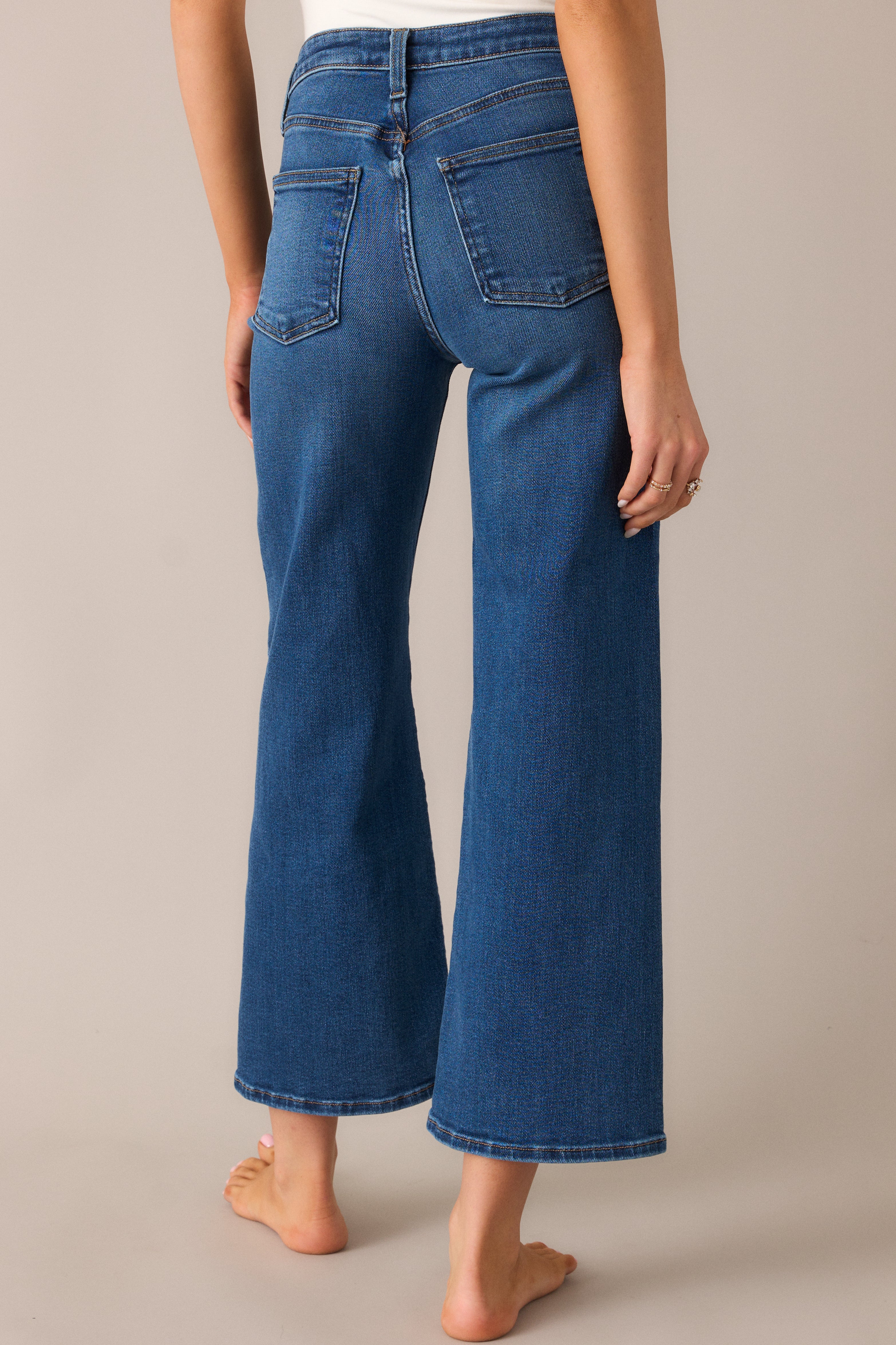 A look from behind showcasing the wide-leg jeans, highlighting the high waist, functional pockets, and the clean, slightly cropped cut for a casual yet stylish finish.