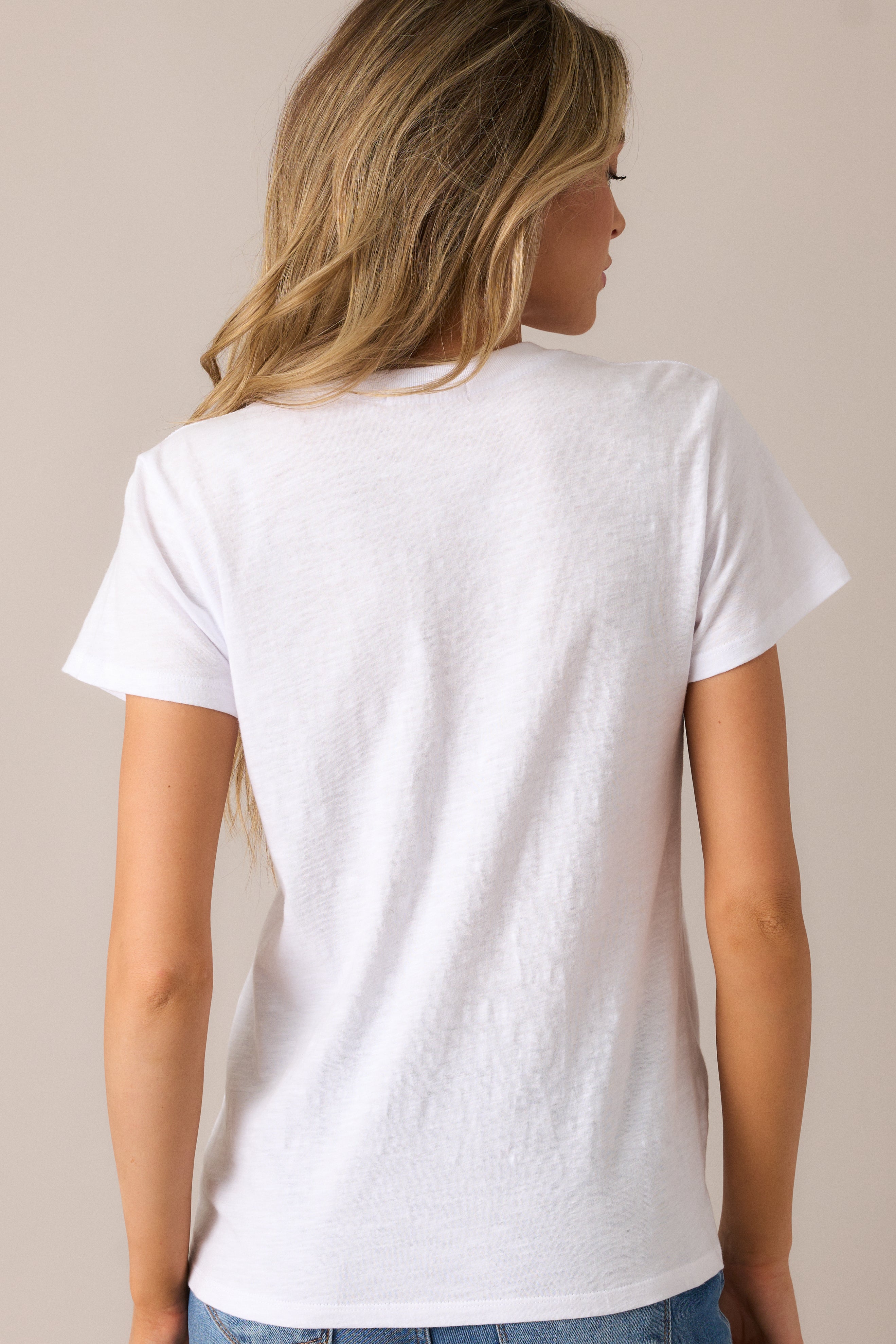 The white tee from behind, showcasing its relaxed fit and clean, minimalist design, perfect for an easy, everyday look.