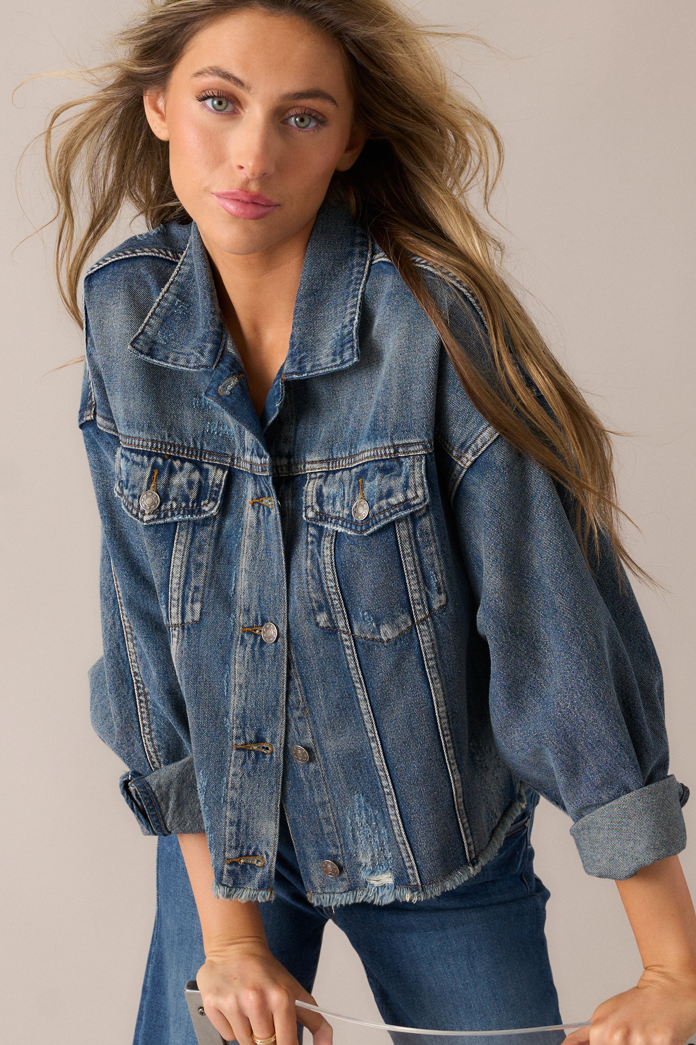  Focused angle on the denim jacket’s bold dolman sleeves and vintage-inspired distressed details.