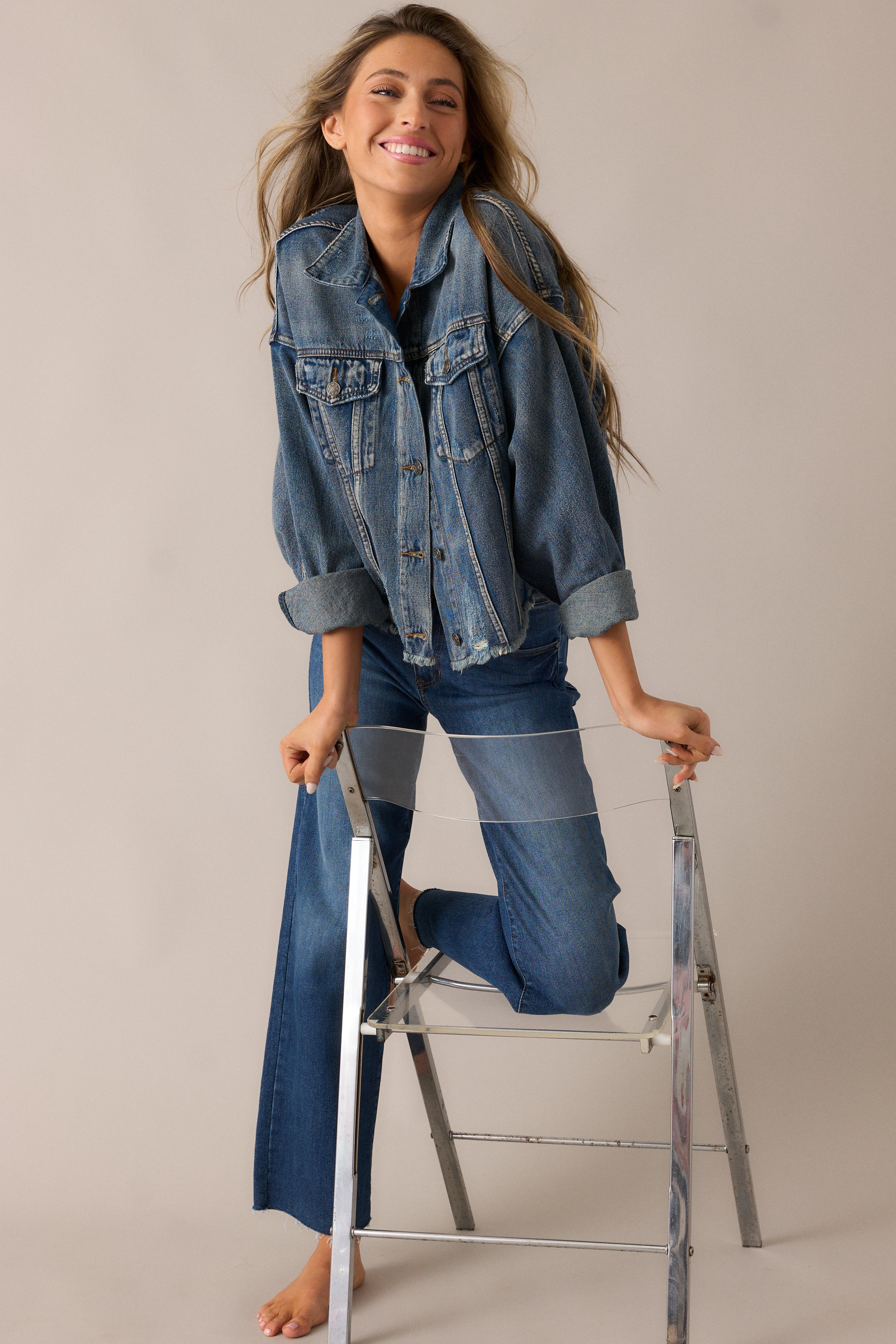 Denim jacket with prominent dolman sleeves, a folded collar, and buttons up the front, styled with a relaxed, effortlessly chic vibe.