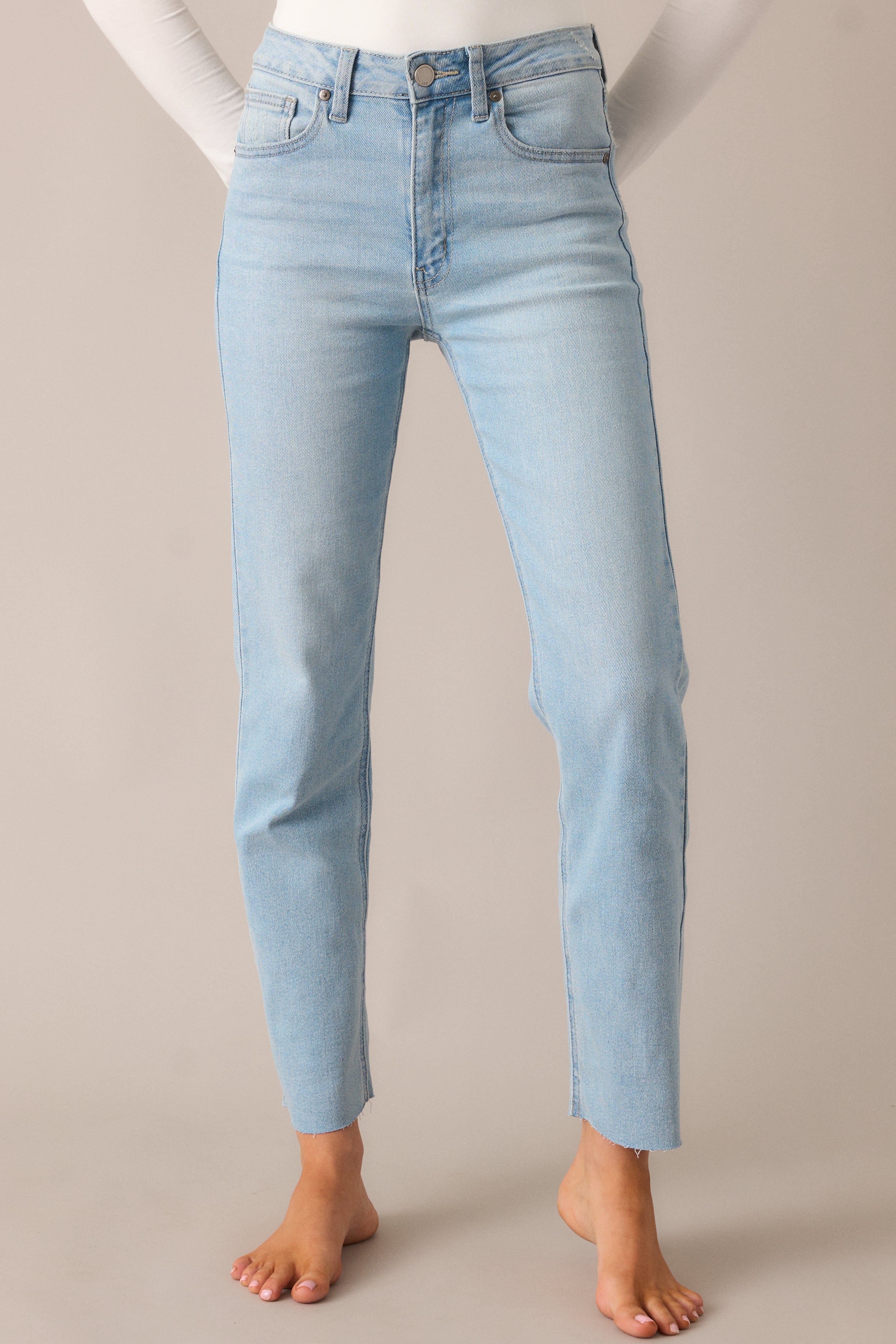 A detailed view of the functional pockets and belt loops, with a focus on the light wash fabric and button zipper closure, giving these jeans a relaxed, classic appeal.