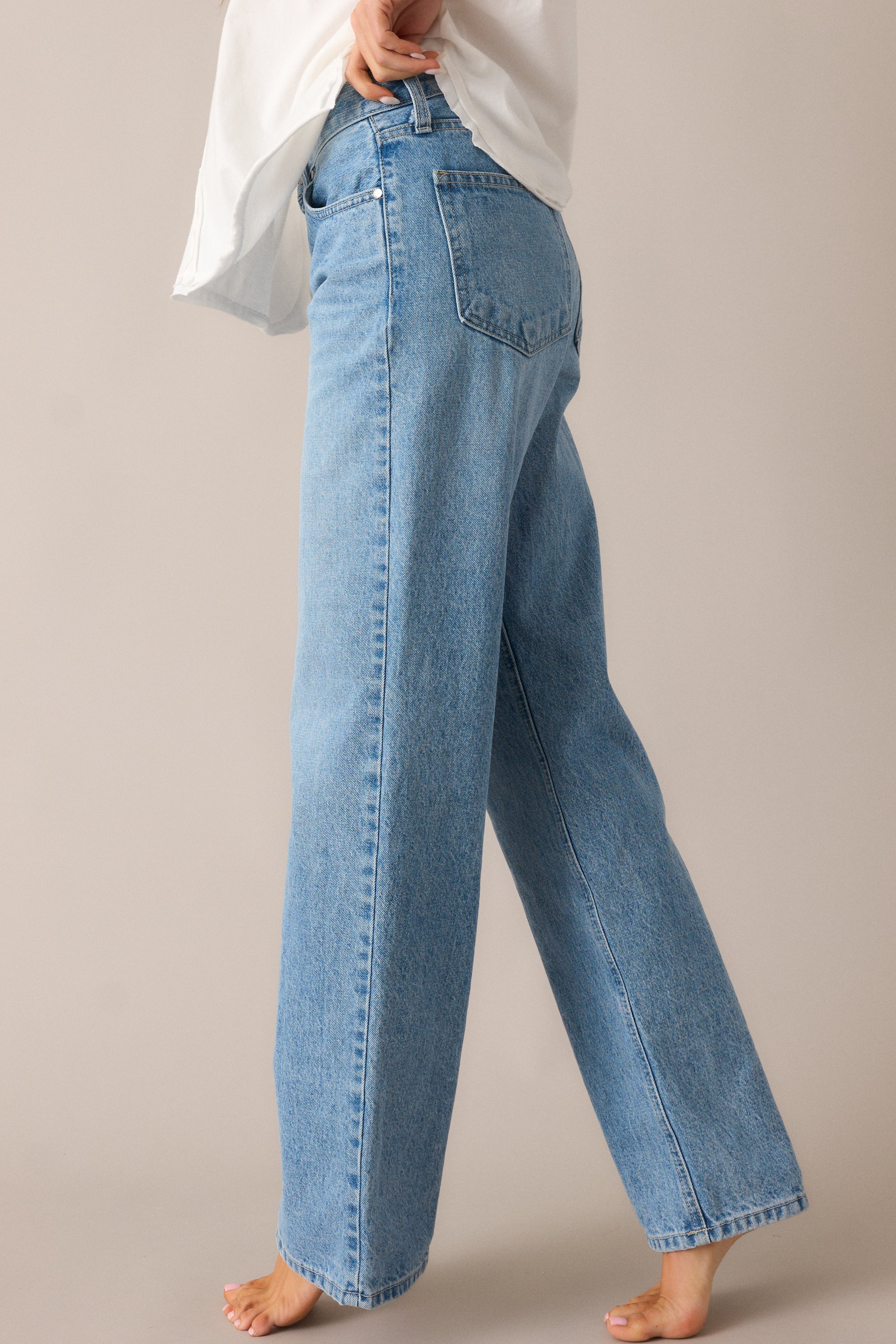 A close-up of the relaxed fit and straight-leg silhouette, showcasing the light wash fabric and the button & zip closure, giving these jeans a timeless, effortless appeal.