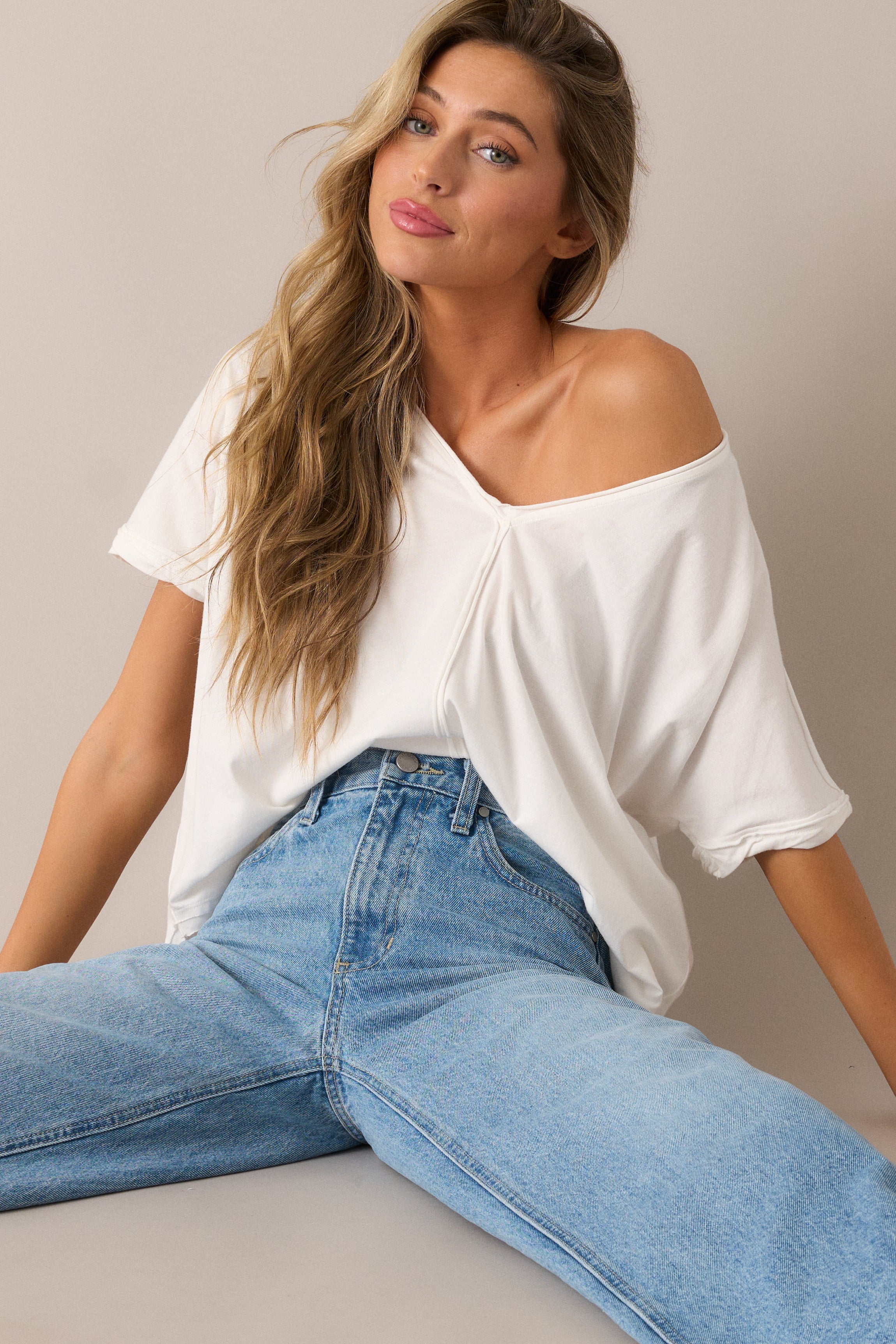 A breezy and versatile top with a relaxed fit, short sleeves, and a v-neckline, complete with vertical front and back hems for a subtle touch of modern style.