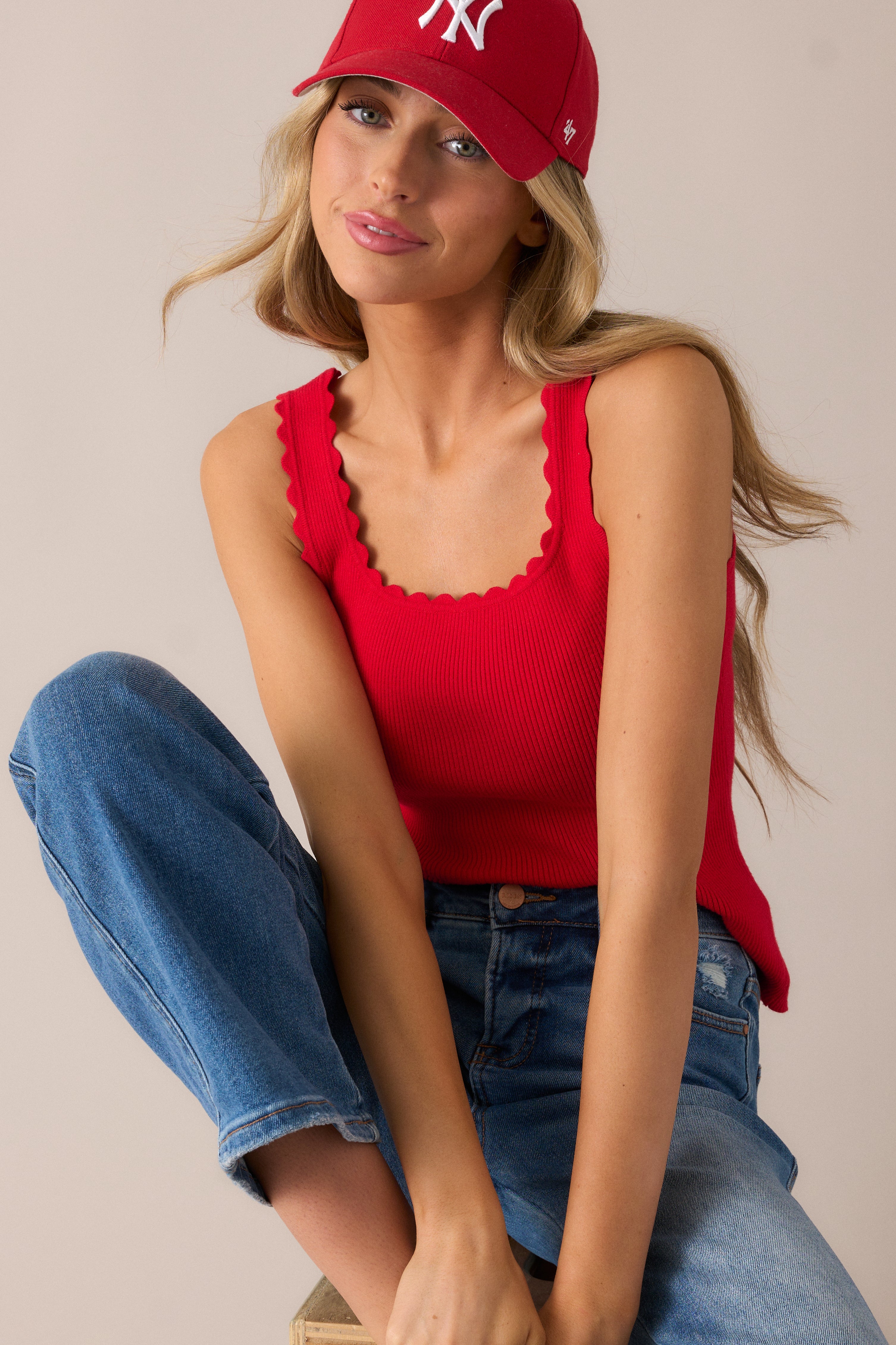 Bold red tank top with a flattering square neckline, scalloped hem, and ribbed fabric, offering a sleeveless design that adds a touch of elegance to any casual outfit.