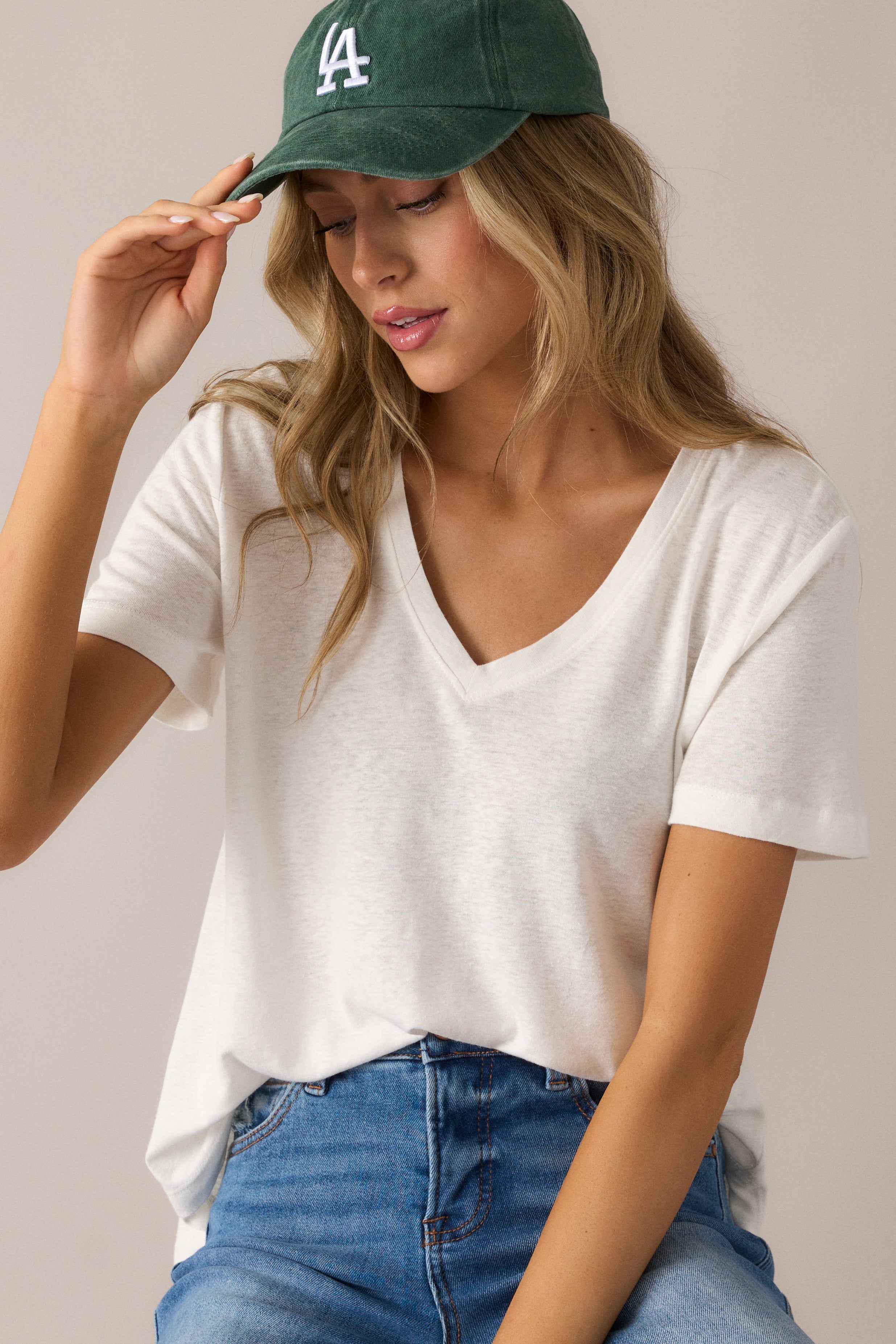 Casual ivory tee showcasing its flowy scoop hemline, washed texture, and breezy short sleeves