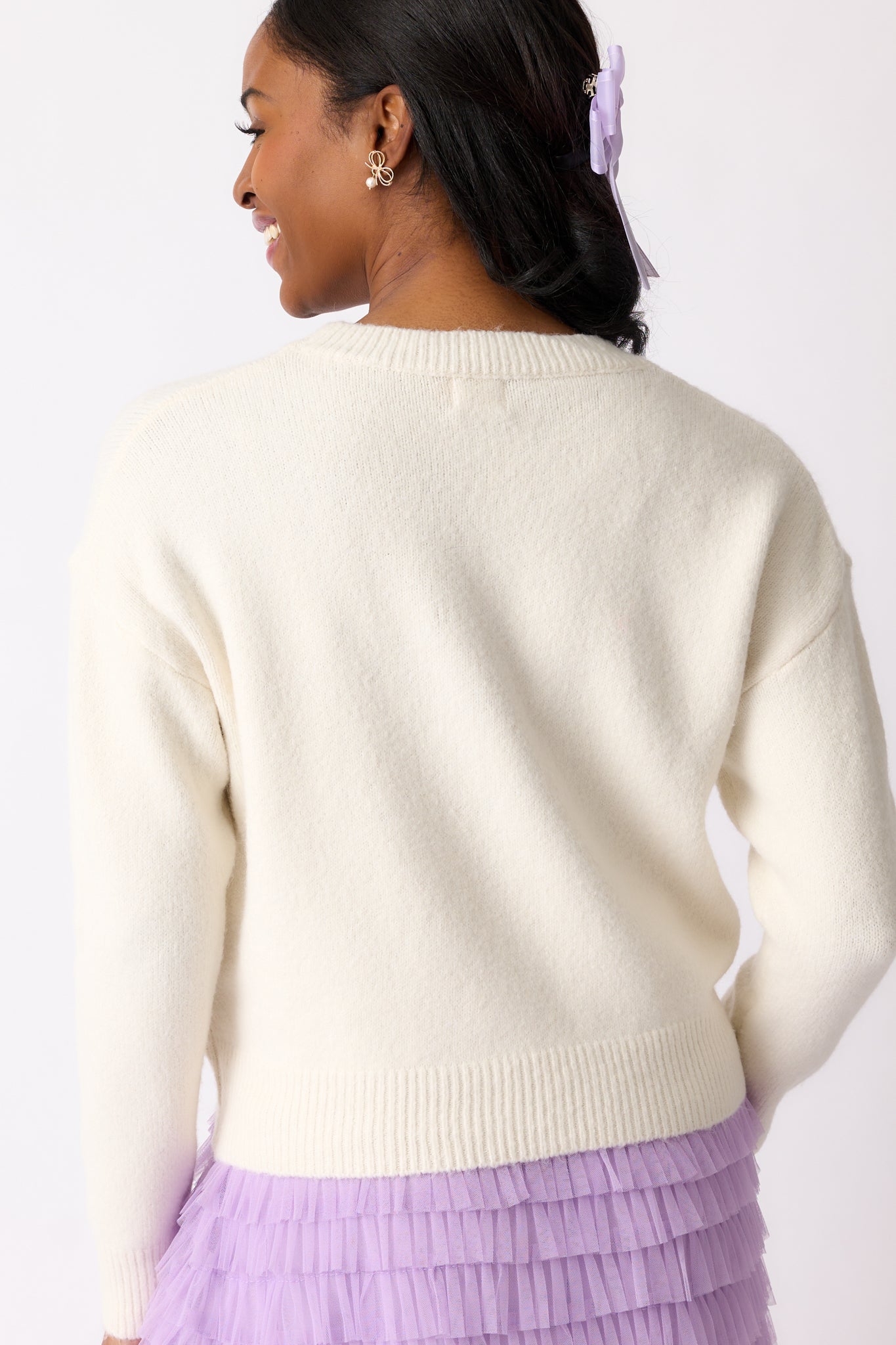 The back of the ivory sweater, showing the relaxed fit, long sleeves, and the clean, minimal design without any stitch details.