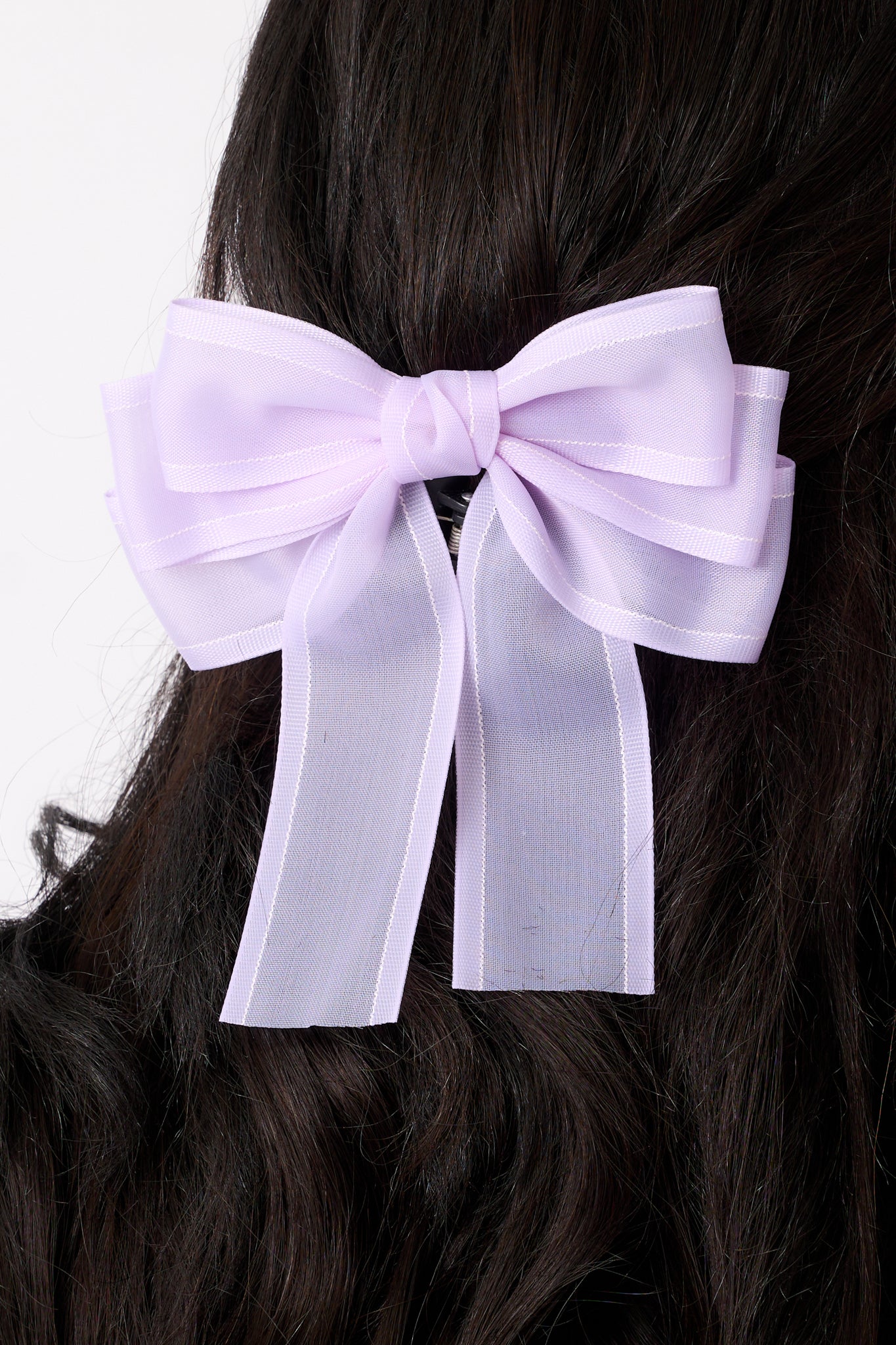 A close-up of the bow's center, focusing on the intricate layering and the subtle texture of the sheer purple fabric.