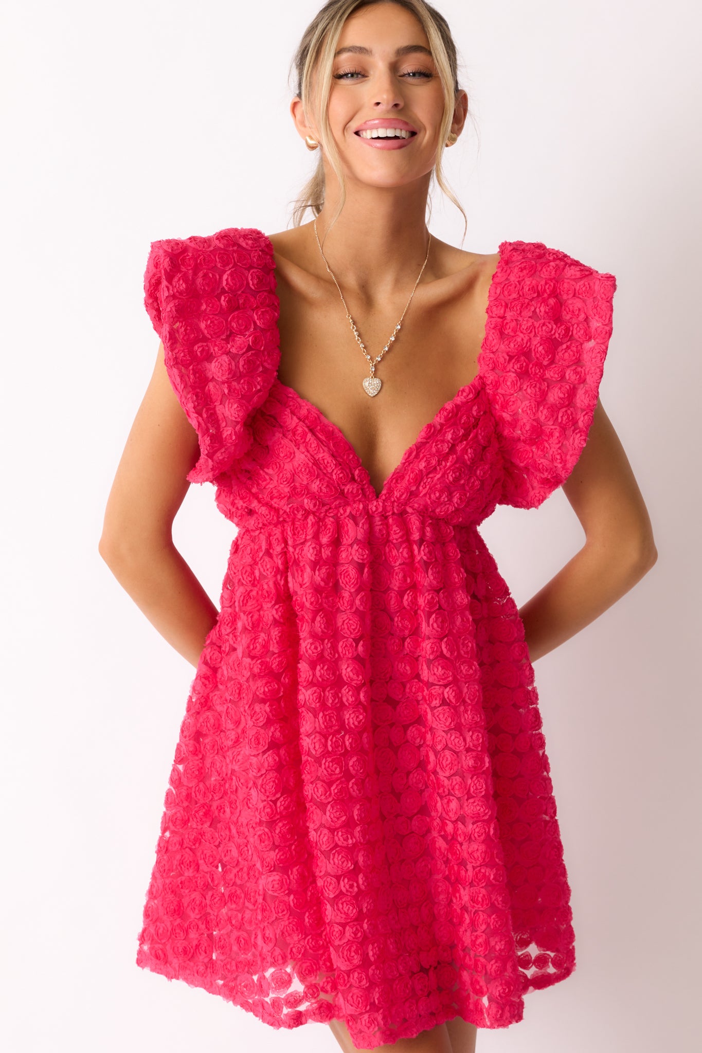 A front cropped view of the hot pink mini dress, emphasizing the babydoll silhouette and the fluttery sleeves in motion.