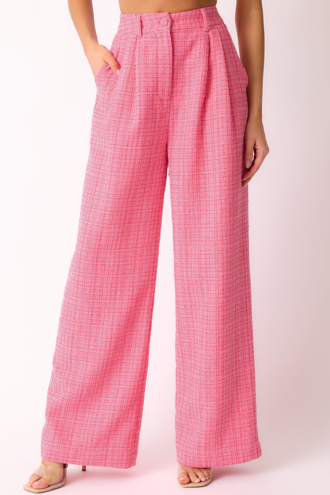 A detailed cropped view of the pink tweed pants highlighting the functional front pockets and the subtle sparkle of the fabric.