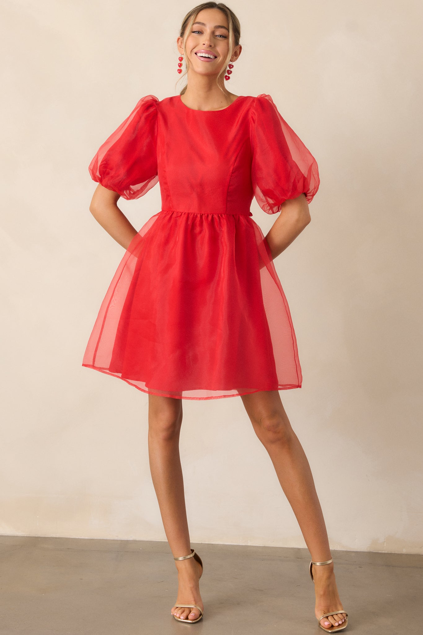 Front view of the red mini dress highlighting the puff sleeves and elegant silhouette of the flare skirt.