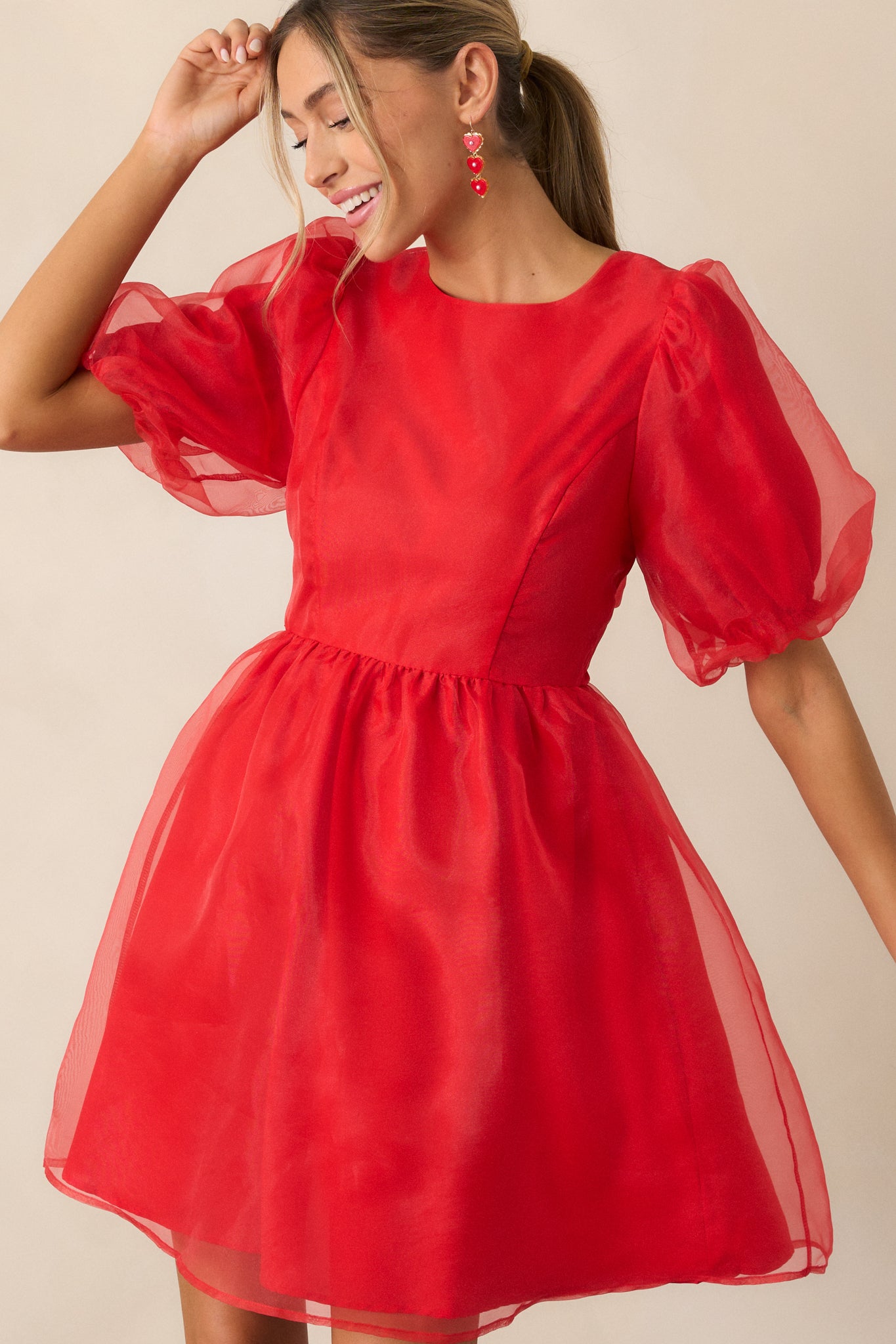 Angled front view of the red mini dress, emphasizing the fit of the bodice and the flow of the flare skirt.