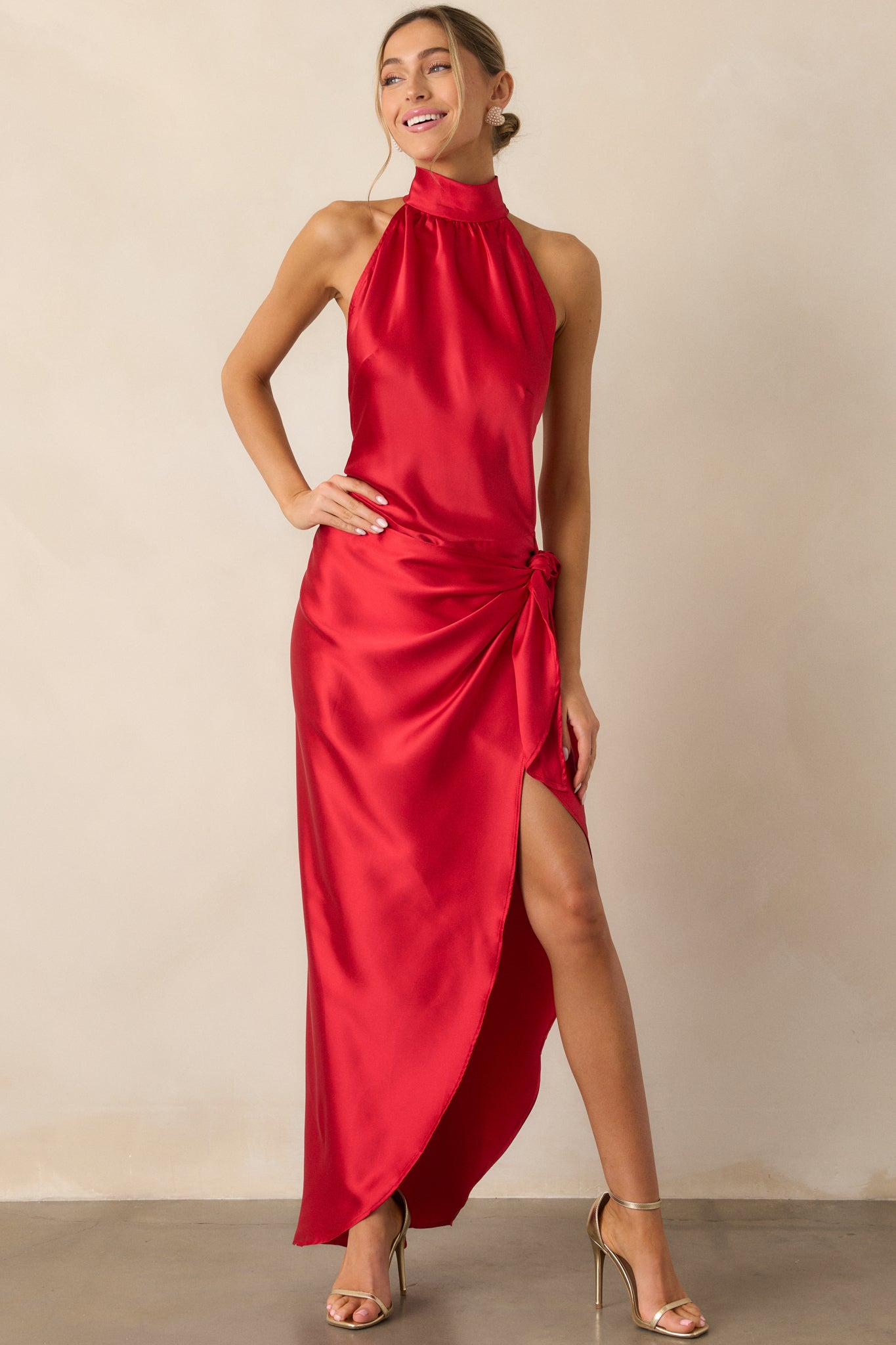 Full-length front view of the red dress highlighting the leg slit and the elegant drape of the skirt.