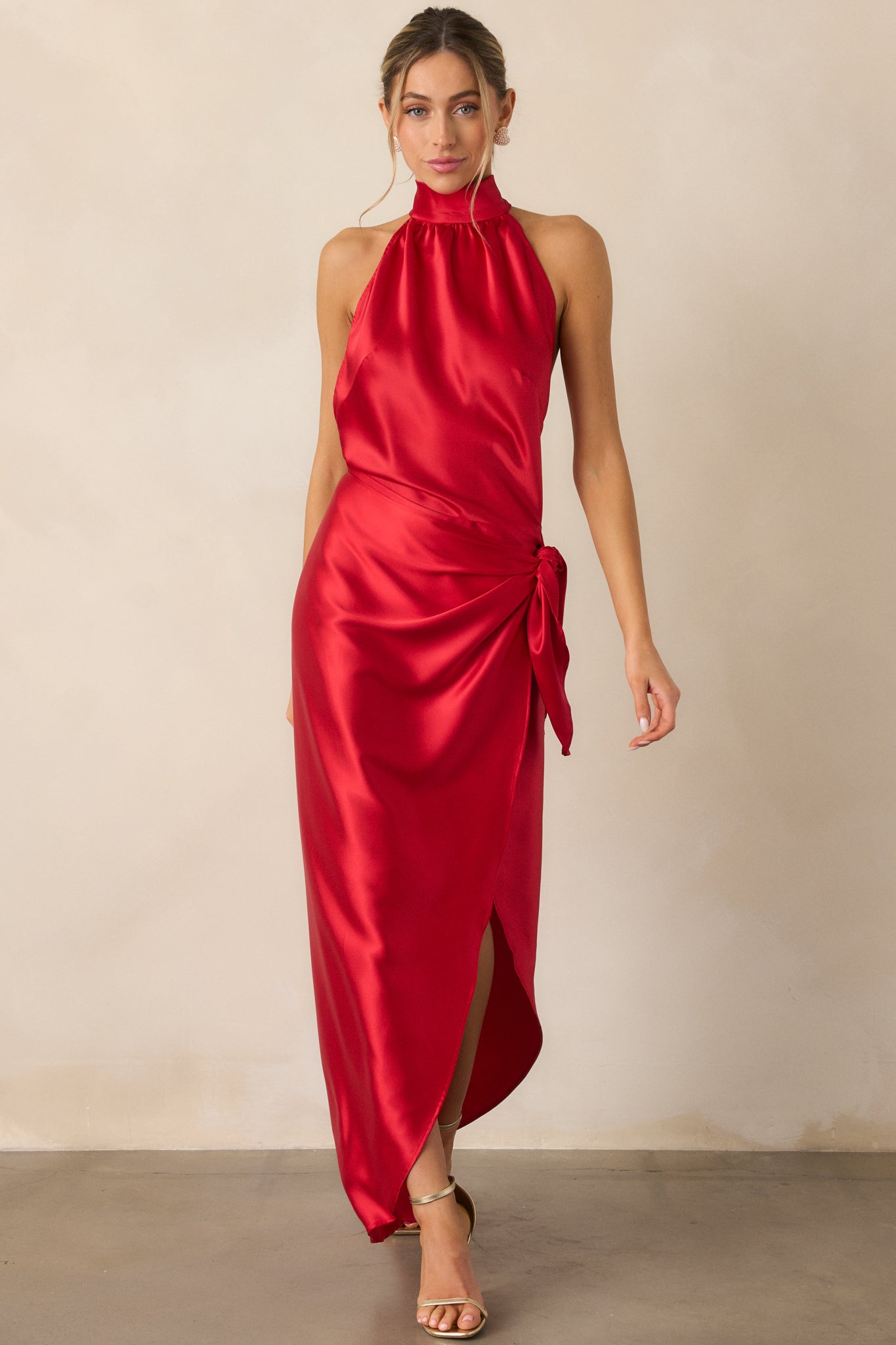 Front view of the red dress showcasing the halter neckline, flowing wrap skirt, and leg slit.