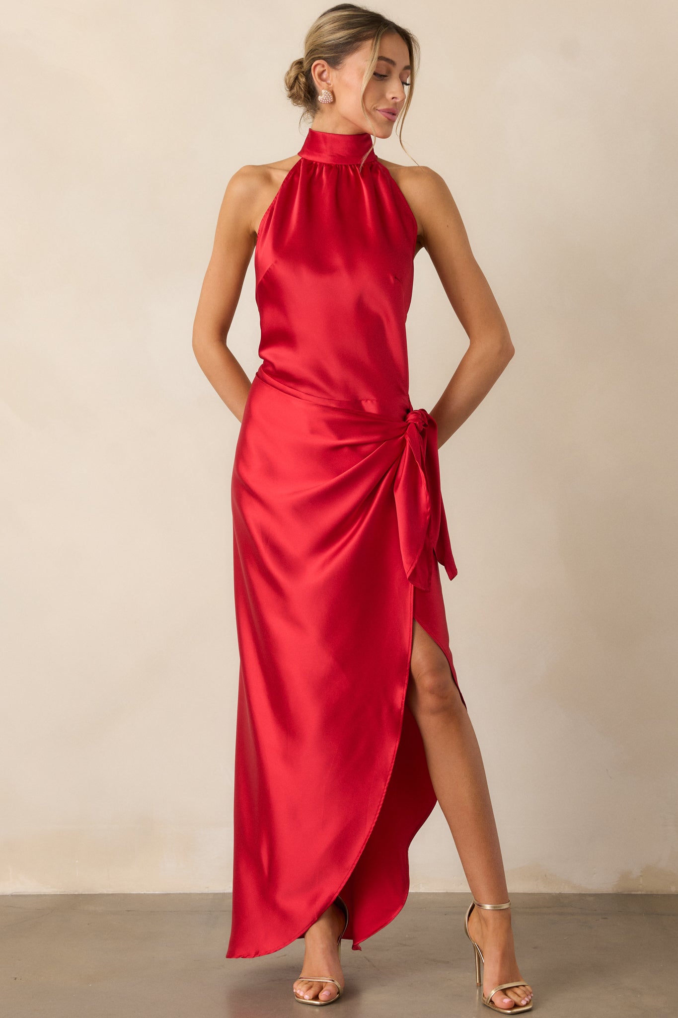 Another front shot of the red dress showcasing the halter neckline, flowing wrap skirt, and leg slit.