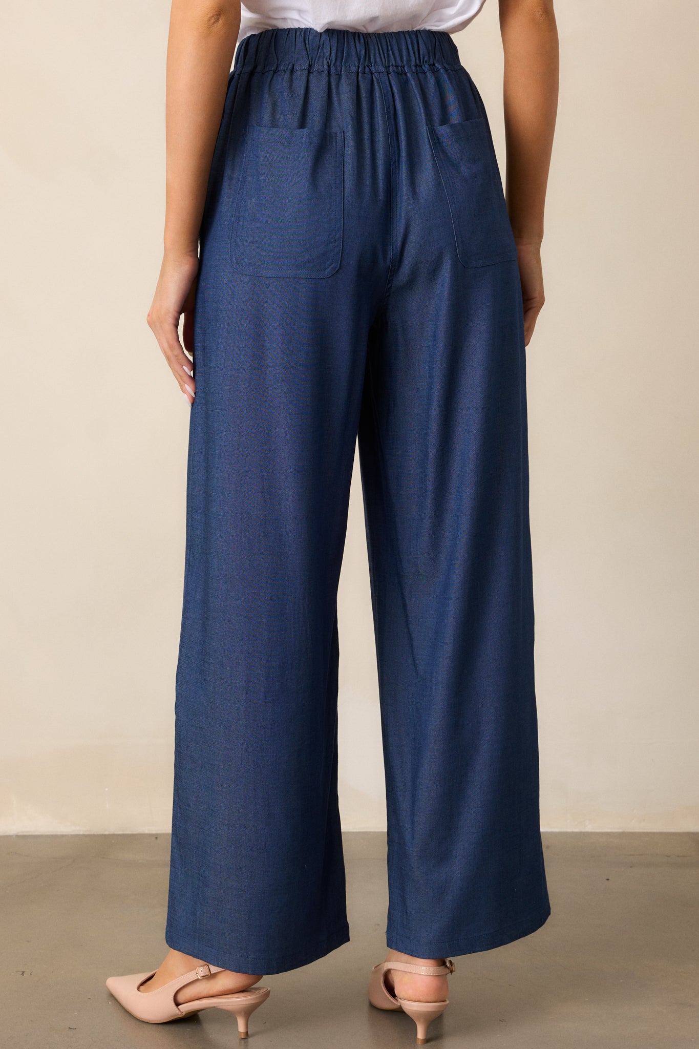 A back view of the dark chambray pants, showing the elastic waistband and seamless wide-leg style.