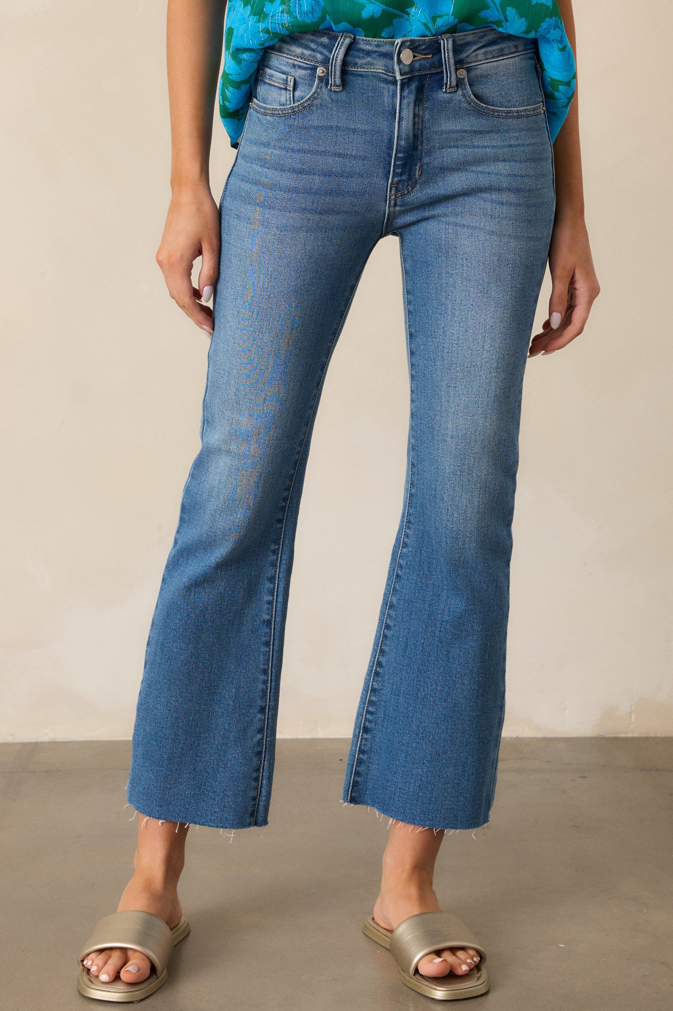 A closer look at the functional belt loops and high-waisted design of the medium wash jeans.