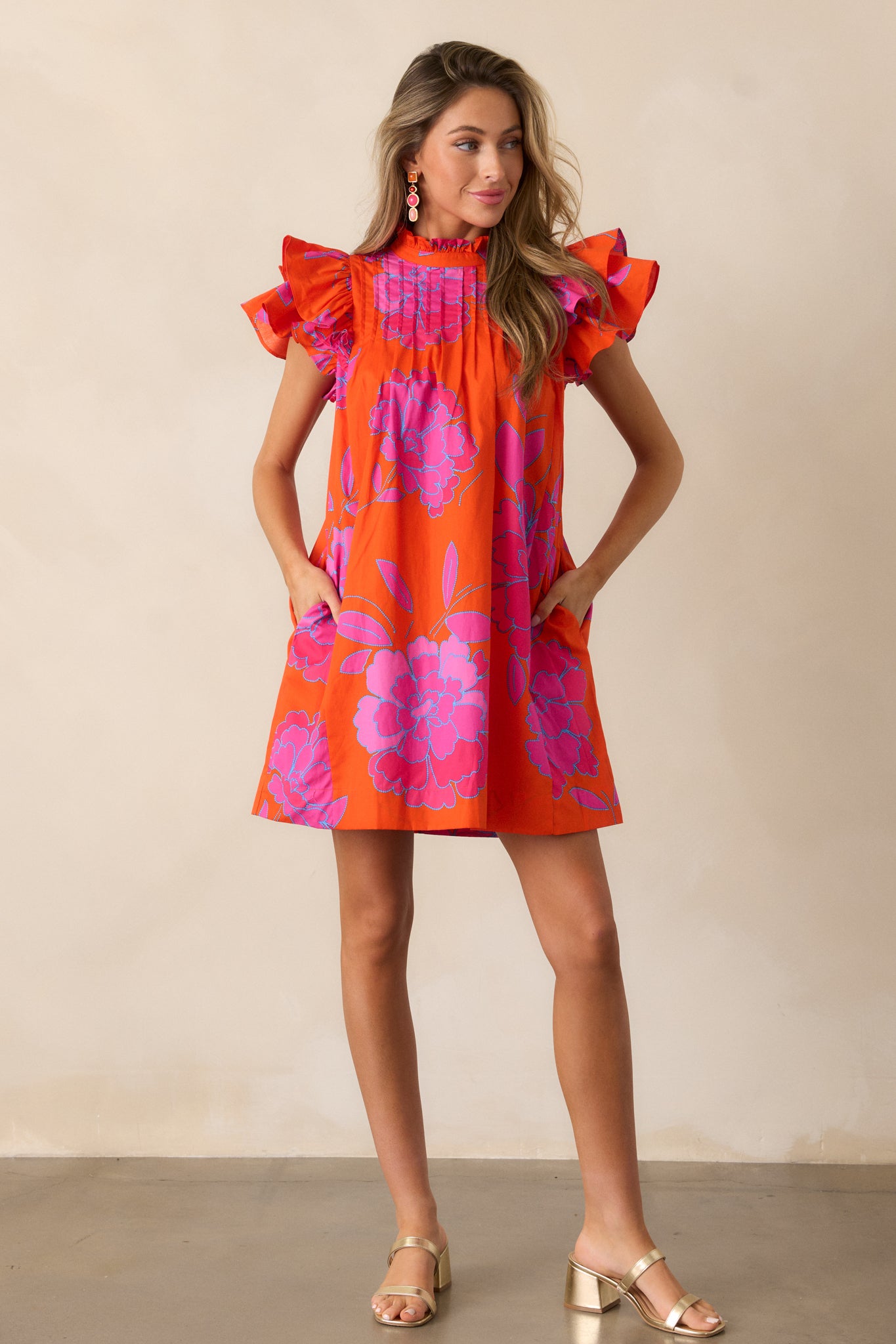  Full-length image of the orange dress, highlighting the pleated yoke detail and flutter sleeve design.