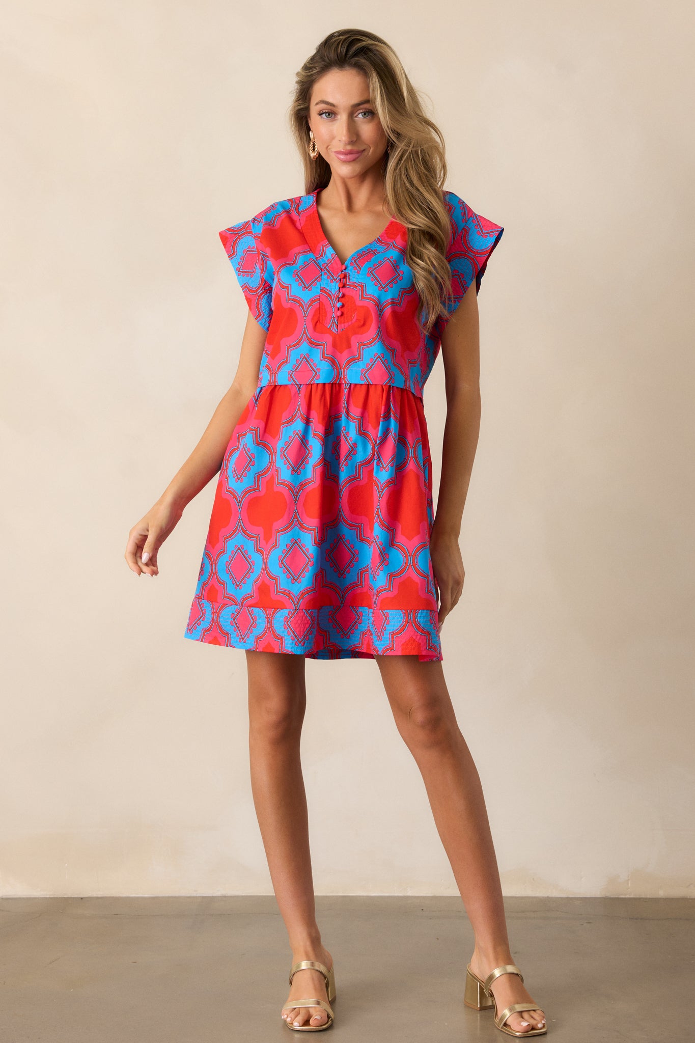 Full-length image of the red dress, emphasizing the vibrant pink and blue print and the flow of the relaxed silhouette.