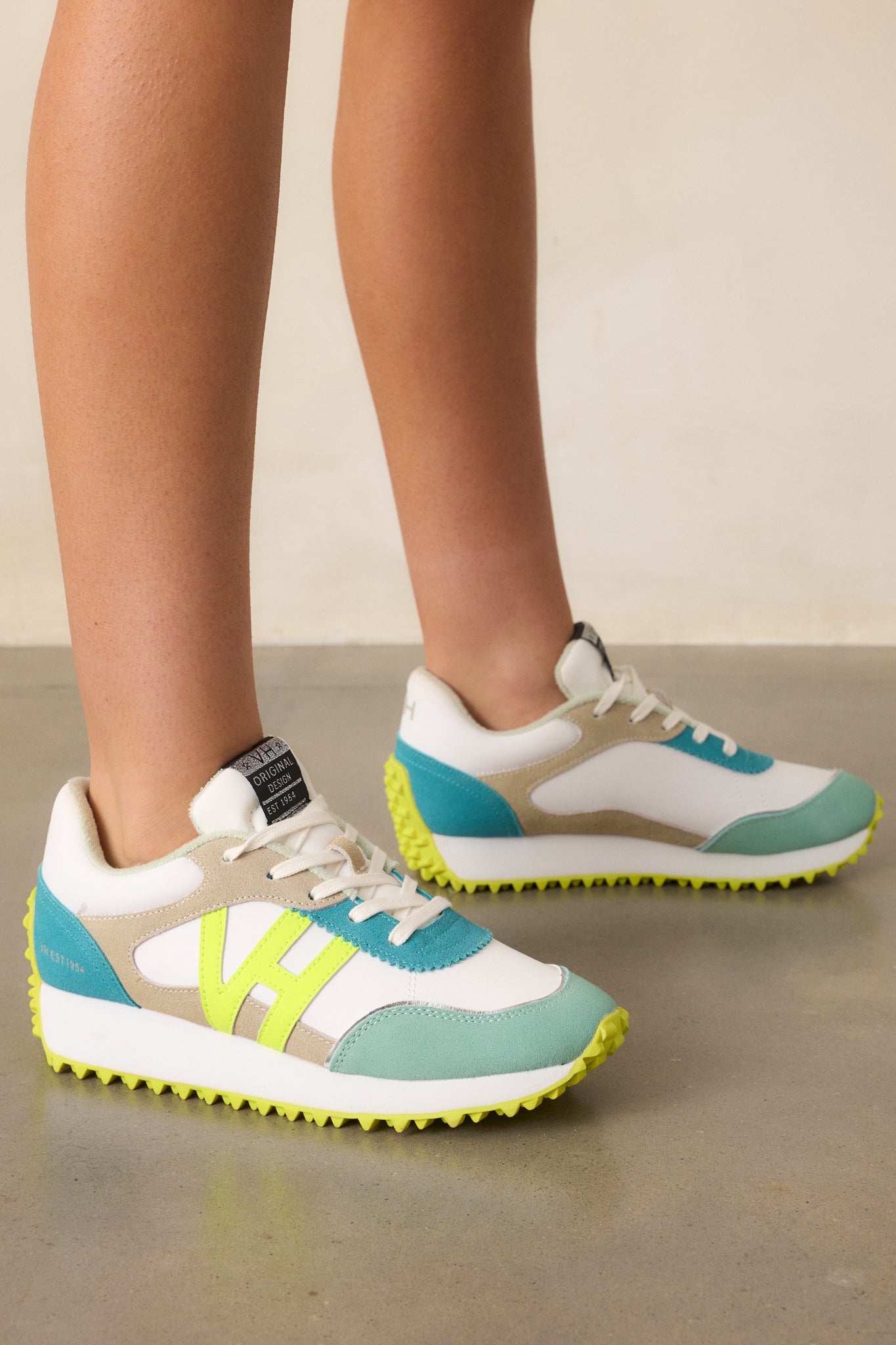 A diagonal view of the neon yellow sneakers, featuring the rounded toe, functional laces, and a slight platform design.