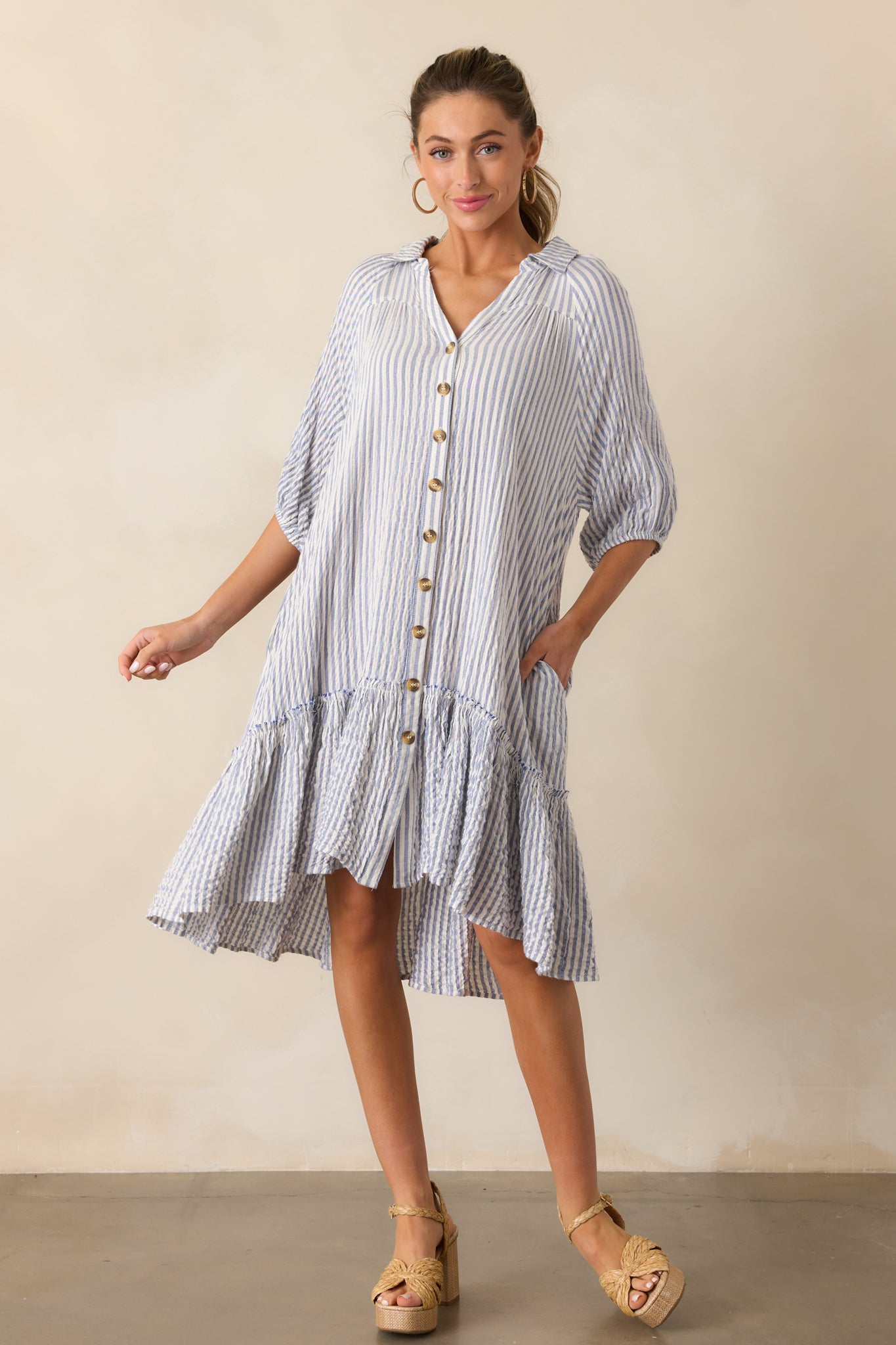 Full body view of the light blue mini dress, highlighting its collared neckline, vertical stripes, and button front.