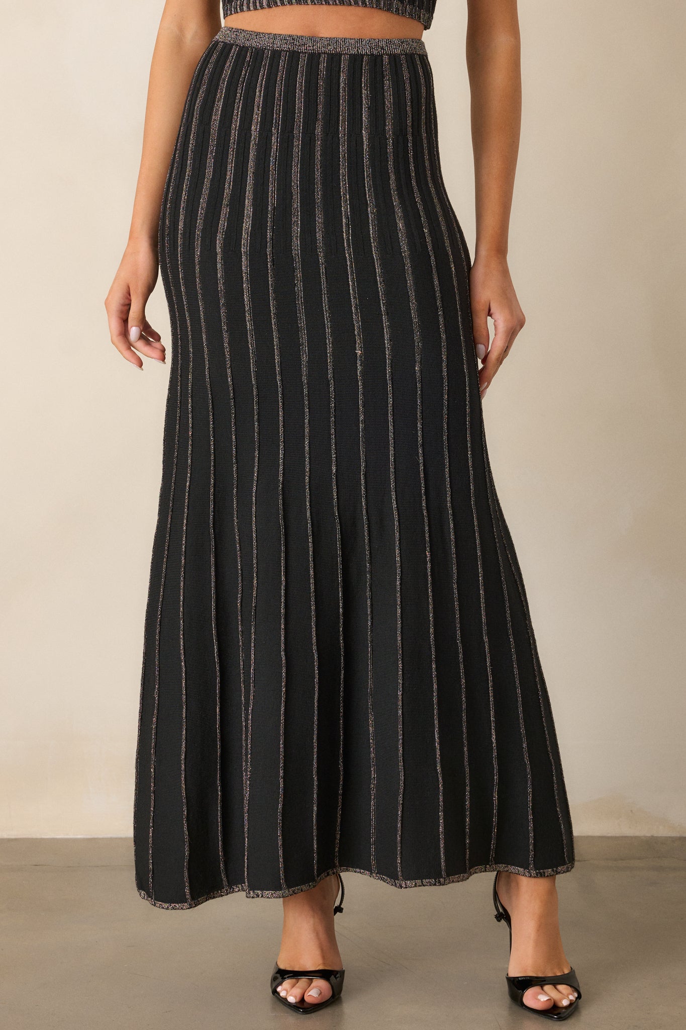 A closer view of the skirt’s waistband and upper portion, highlighting the knit texture and the horizontal champagne stripe details.