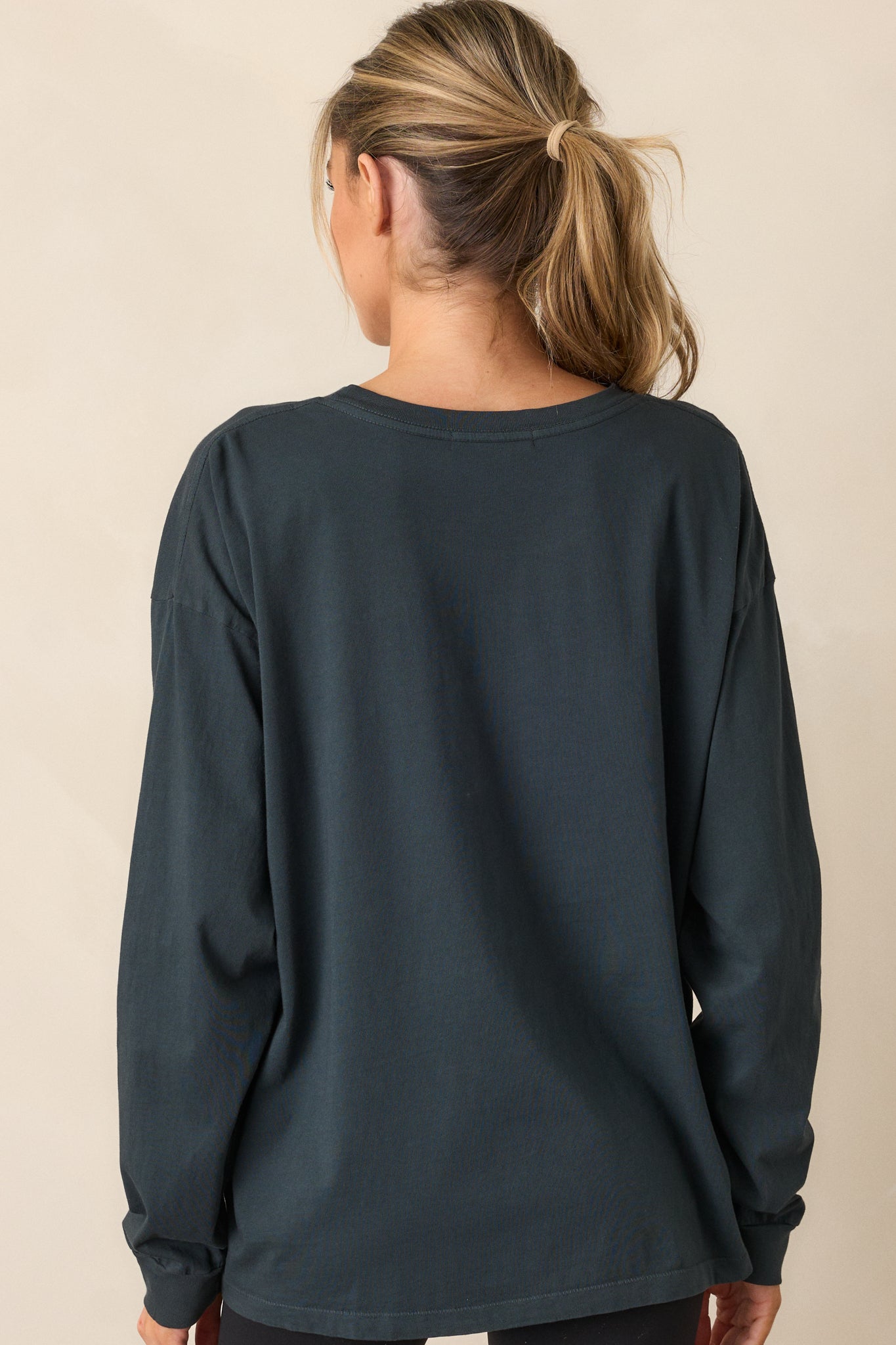 Back view of the vintage black tee highlighting its plain design, long sleeves, and relaxed fit.