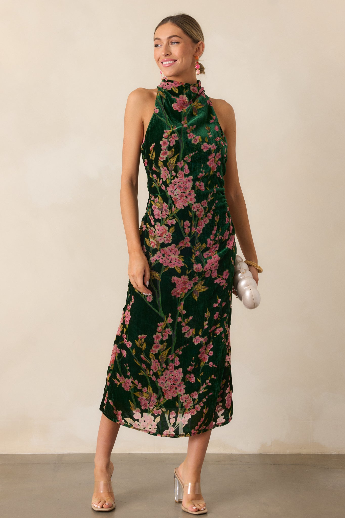 A complete view of the green maxi dress, highlighting the interplay of its floral pattern and the smooth velvet texture.